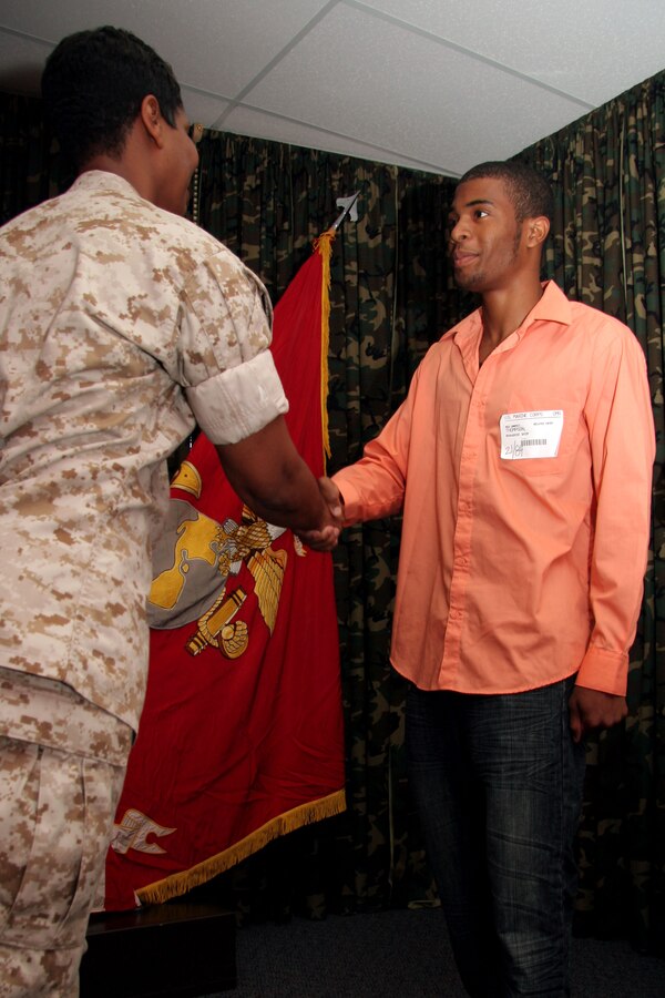 Chief Warrant Officer 4 Nicole Holt, 9th Marine Corps District headquarters personnel officer, shakes hands with her son, Rhaashid Thompson, after his oath of enlistment July 1. Thompson has two parents who have both served nearly 20 years in the Marine Corps. Thompson is looking to give the Corps four years as a data network technician.