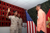 Chief Warrant Officer 4 Nicole Holt, 9th Marine Corps District headquarters personnel officer, leads her son, Rhaashid Thompson, in the oath of enlistment as her husband, Sgt. Maj. Scott Holt, Recruiting Station Kansas City's sergeant major, oversees. Thompson is the son of two Marines who have both served nearly 20 years. He will continue the legacy as a data network technician.