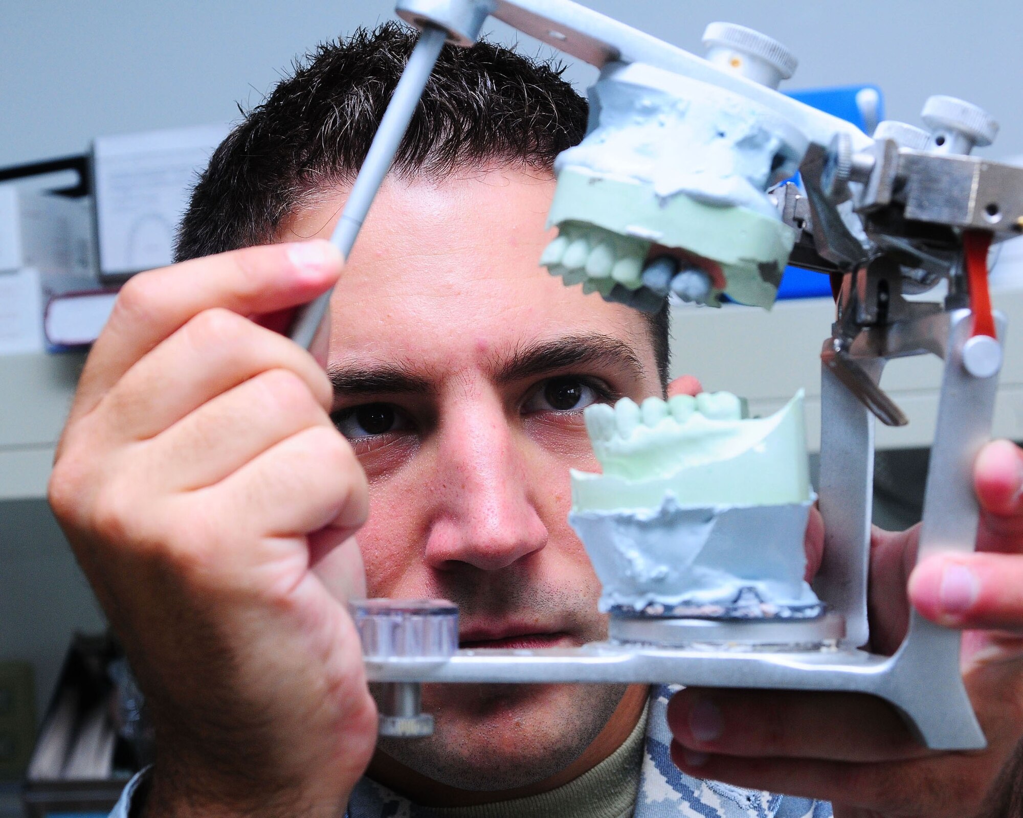 YOKOTA AIR BASE, Japan--Senior Airman Mike Watson, 374th Dental Squadron dental laboratory technician, uses an articulator to check for a crown insertion in a patient's bite June 26. An articulator is a special device that is used to models of your teeth. The dental laboratory specializes in making crowns, dentures, retainers, and bridges for their patients.  (U.S. Air Force photo/Airman 1st Class Sean Martin)	