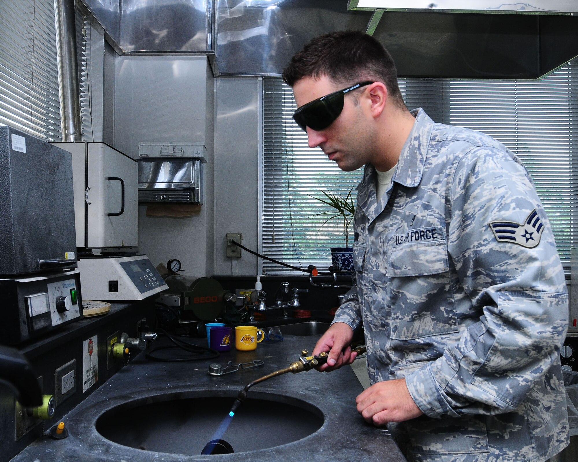 YOKOTA AIR BASE, Japan--Senior Airman Mike Watson, 374th Dental Squadron dental laboratory technician, melts metal that will be used for the stone mold of a crown June 26. The dental laboratory specializes in making crowns, dentures, retainers, and bridges for their patients.  (U.S. Air Force photo/Airman 1st Class Sean Martin)