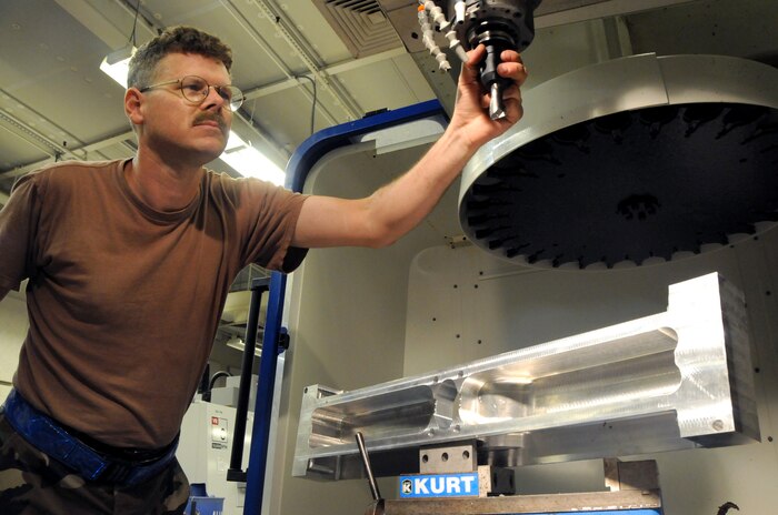 Tech. Sgt. Stephen Sarkany inserts a high speed drill bit into a vertical machining center drill at the metals technology shop here July 1. The drill was used to fabricate a section of cargo flooring for a damaged C-17 from a piece of unformed aluminum. Sergeant Sarkany is the swing shift supervisor for the 437 MXS metals technology shop. (U.S. Air Force photo/Staff Sgt. Daniel Bowles)