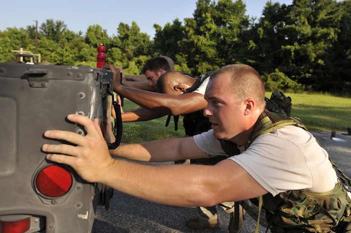 Staff Sgt. Daniel Ackerman and a team of Airmen push a High Mobility Multipurpose Wheeled Vehicle during an obstacle course here June 24. Sergeant Ackerman and his team are preparing for the Rodeo 2009 obstacle course. Airmen compete during Rodeo in their specialties including maintenance, cargo loading, air drops, aerial refueling and more than 30 other events. The Airmen are air transportation specialists with the 437th Aerial Port Squadron. (U.S. Air Force photo/James M. Bowman) (RELEASED)