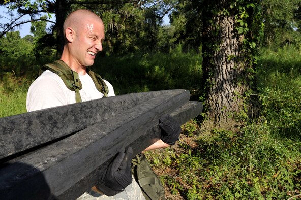 Senior Airman Jason Golden carries logs during an obstacle course here June 24. He is preparing to compete in the obstacle course scheduled for Rodeo 2009. Rodeo focuses on improving worldwide air mobility forces' professional core abilities. Airman Golden is an air transportation specialist with the 437th Aerial Port Squadron. (U.S. Air Force photo/James M. Bowman) (RELEASED)