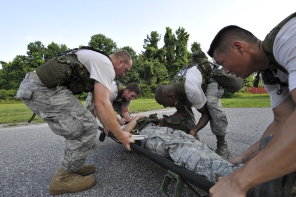 Airmen position a team member onto a litter during an obstacle course held here June 24. The Airmen are preparing for the Rodeo 2009 obstacle course. Rodeo 2009 will mark the 30th anniversary of the Mobility Air Force's readiness competition. The Airmen are air transportation specialists with the 437th Aerial Port Squadron. (U.S. Air Force photo/James M. Bowman) (RELEASED)