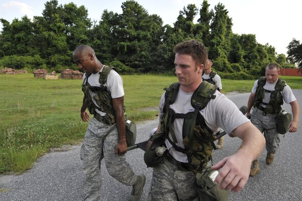 Airmen carry a simulated injured team member on a litter during an obstacle course held here June 24. The Airmen are preparing for the Rodeo 2009 readiness competition. Rodeo 2009 is scheduled to be held at McChord AFB, Wash., July 19-25. The Airmen are air transportation specialists with the 437th Aerial Port Squadron. (U.S. Air Force photo/James M. Bowman) (RELEASED)