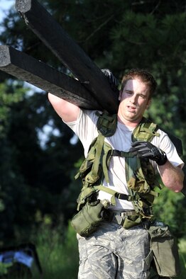 Senior Airman James Tench carries logs during an obstacle course here June 24. Airman Tench is building his endurance for the Rodeo 2009 obstacle course. Rodeo 2009 is the Mobility Air Force's readiness competition. Airman Tench is an air transportation specialist with the 437th Aerial Port Squadron. (U.S. Air Force photo/James M. Bowman) (RELEASED)