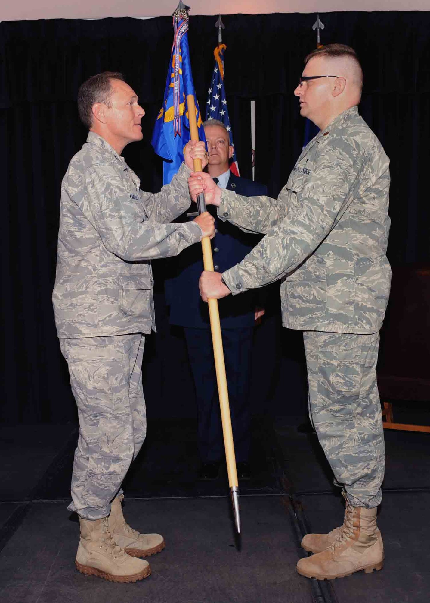CANNON AIR FORCE BASE, N.M. -- (left) Col. Steven Kimball, 27th Special Operations Mission Support Group commander, passes the 27th Special Operations Force Support Squadron guidon to Maj. Frederick Gearhart during a change of command ceremony here July 1. Major Gearhart assumed command of the squadron from the outgoing commander, Maj Richard McKee, who led the 27 SOFSS from January 9, 2009, to July 1, 2009 and through its transformation from 27th Special Operations Services Squadron to 27 SOFSS.  (U.S. Air Force photo by Airman 1st Class James Bell)