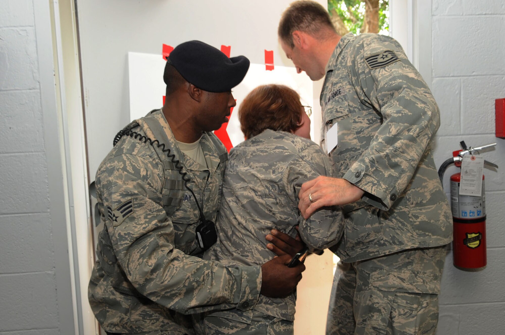 LANGLEY AIR FORCE BASE, Va. -- Second Lt. Kristine Shinkle, 1st Medical Group clinical nurse, simulates an escape attempt before being stopped by Senior Airman Carl Bray, 1st Security Forces Squadron corrections non-commissioned officer in charge, and Tech. Sgt. Eric McCoy, 94th Fighter Squadron independent duty medical technician, during the first multi-facility Skeeter Swatt 2009 exercise here June 18. The exercise evaluated how well the 1st MDG coordinated with local emergency management organizations to dispense medication following a simulated Anthrax outbreak. (U.S. Air Force photo/Senior Airman Ashley Hawkins)