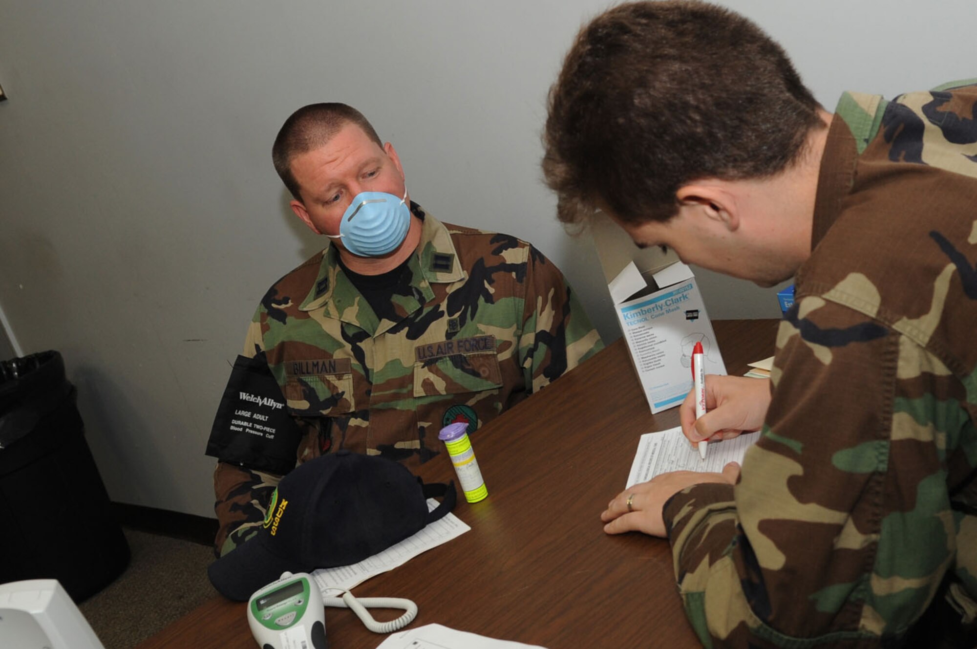 LANGLEY AIR FORCE BASE, Va. -- Capt. Tyler Cooke, 1st MDG blue clinic physician, evaluates Capt. Keith Billman, 1st Medical Group information systems chief, who is complaining of flu-like symptoms, during the first multi-facility Skeeter Swatt 2009 exercise here June 18. The exercise evaluated how well the 1st MDG coordinated with local emergency management organizations to dispense medication following a simulated Anthrax outbreak. (U.S. Air Force photo/Senior Airman Ashley Hawkins)