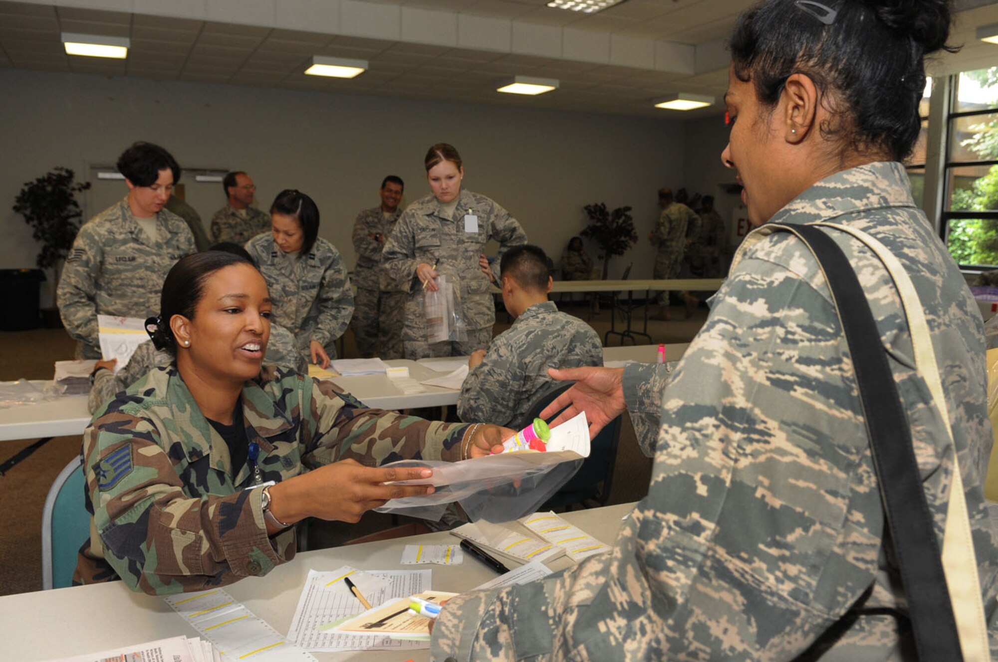 LANGLEY AIR FORCE BASE, Va. -- Staff Sgt. Patrina James, 1st Medical Group pharmacy technician, dispenses medication to Maj. Ketu Lincoln, 1st MDG dental officer, during the first multi-facility Skeeter Swatt 2009 exercise here June 18. The exercise evaluated how well the 1st MDG coordinated with local emergency management organizations to dispense medication following a simulated Anthrax outbreak. (U.S. Air Force photo/Senior Airman Ashley Hawkins)