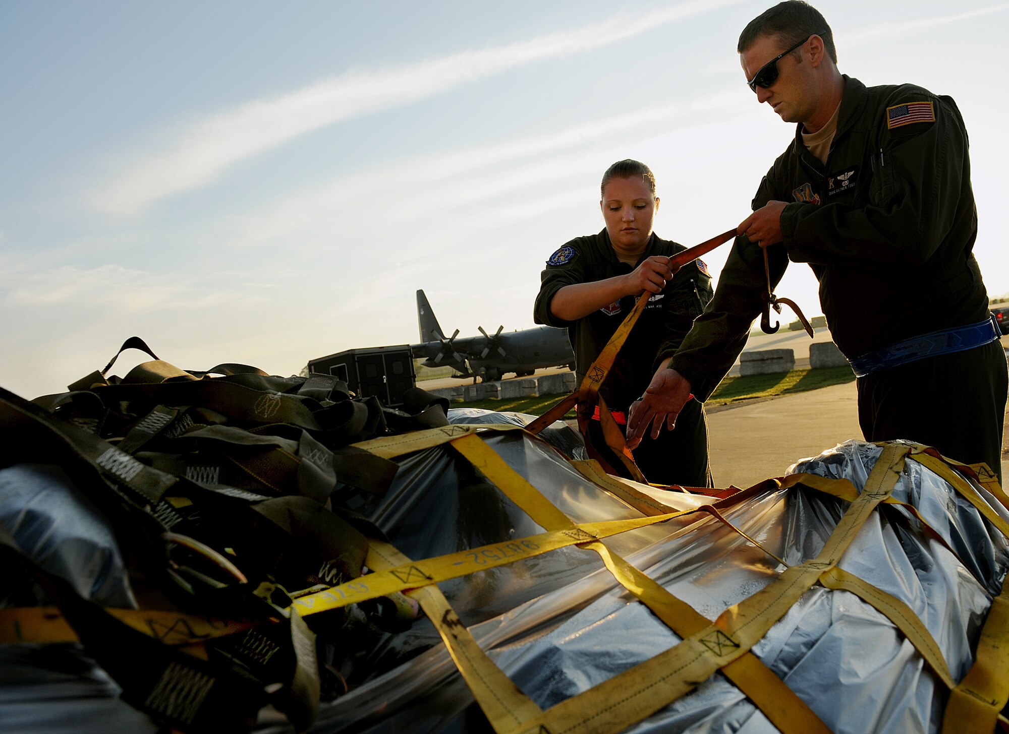 MOODY AIR FORCE BASE, Ga. -- Airman 1st Class Aryn May, 71st Rescue Squadron loadmaster, and Tech. Sgt. Christopher Giltner, 71st RQS flight engineer, strap down cargo before loading it onto a HC-130P Combat King here July 1. Sergeant Giltner and Airman May will participate in Saber Talisman, one of the largest multinational exercises in the world. (U.S. Air Force photo by Airman 1st Class Joshua Green)
