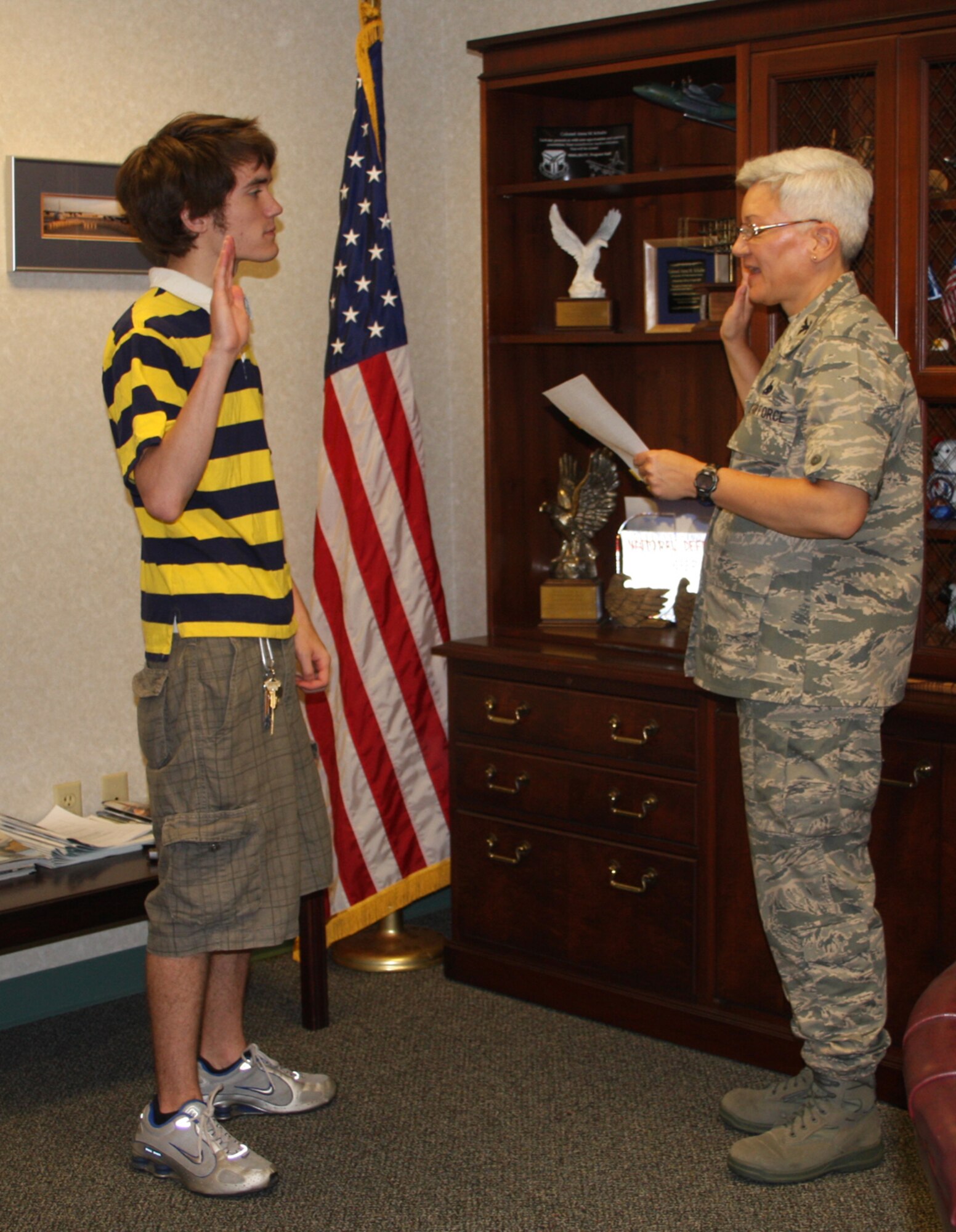 WRIGHT-PATTERSON AIR FORCE BASE, Ohio - Col. Anna Schulte, 445th Airlift Wing Maintenance Group commander, administers the Oath of Enlistment to her youngest son, Kristofer, June 23.  Kristofer is going into the Air Force Reserves. (Air Force photo/Stacy Vaughn)