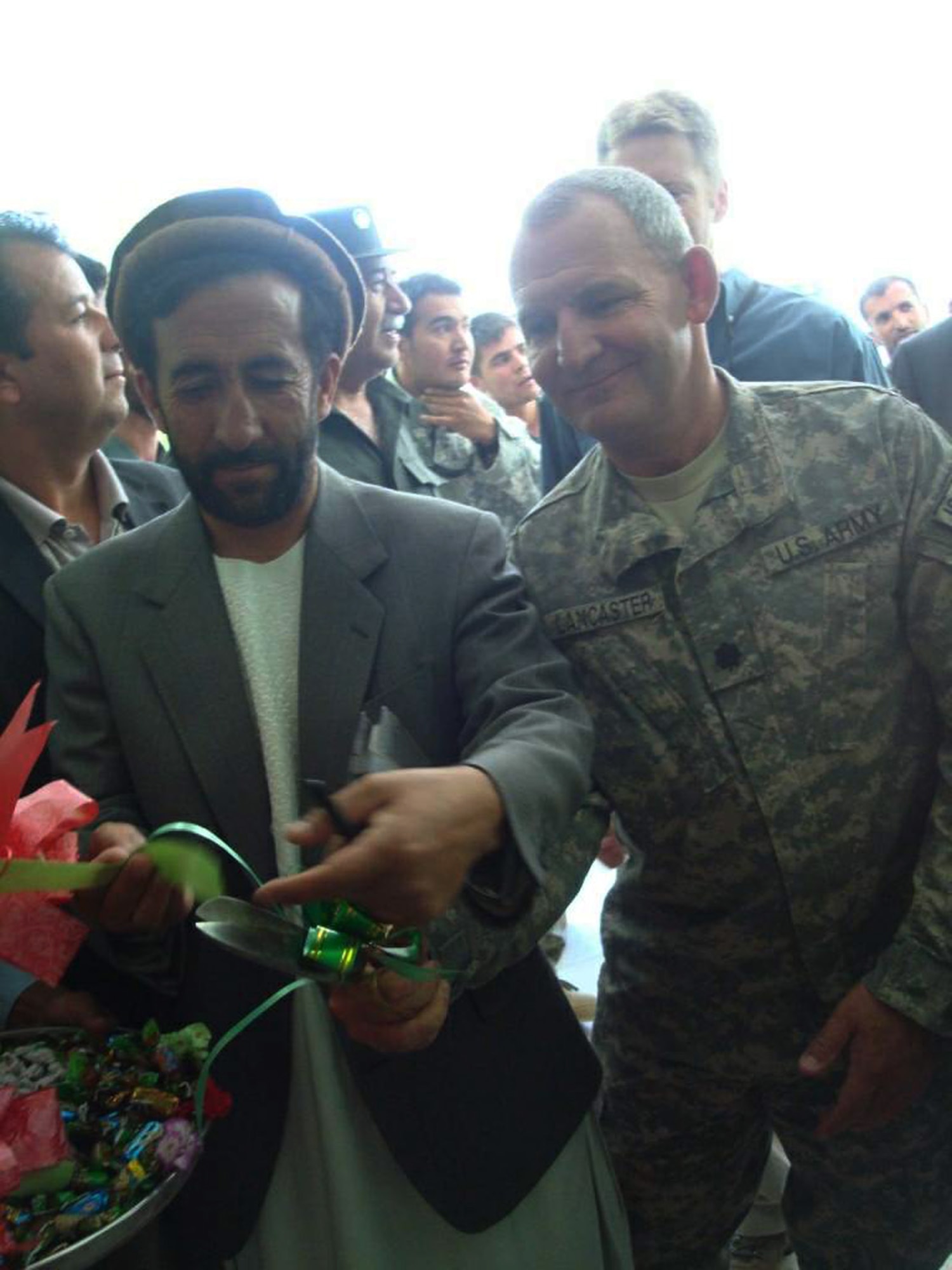 Army Lt. Col. Steve Lancaster helps an Afghan provincial leader cut the official ribbon during the grand opening of the Haish Saidqi Girls' School June 23 in the Panjshir Province, Afghanistan. Colonel Lancaster is the Provincial Reconstruction Team commander. (U.S. Air Force photo/Capt. Stacie N. Shafran) 
