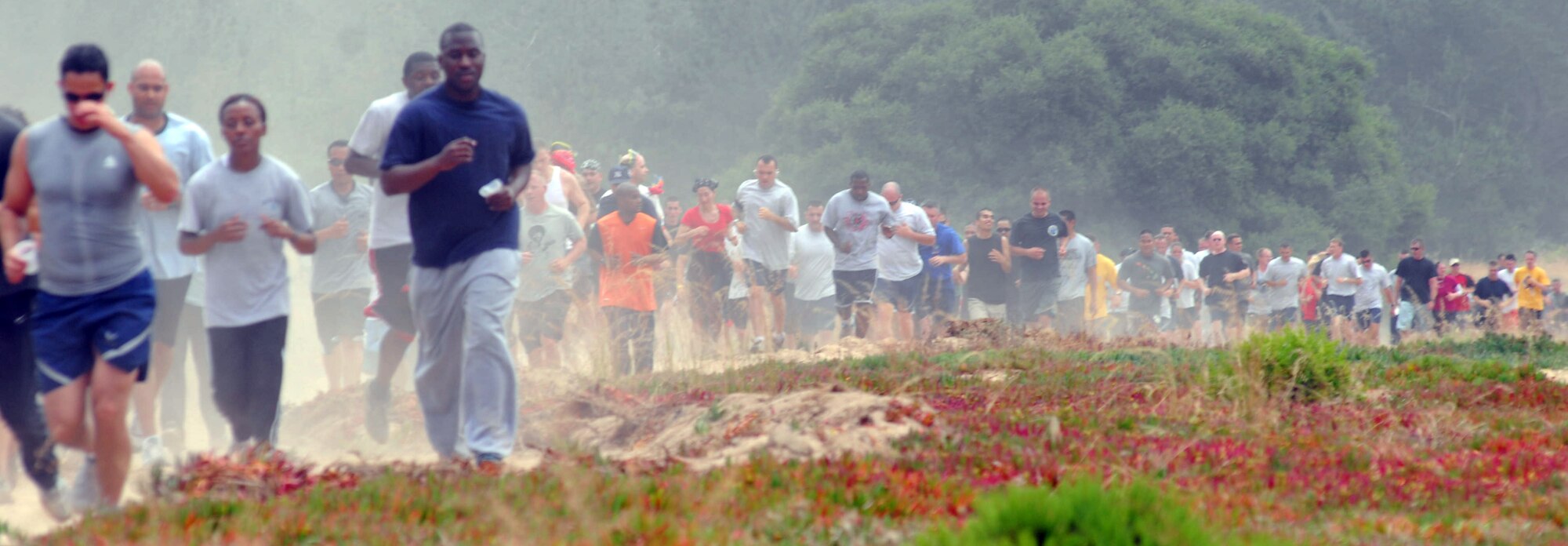 VANDENBERG AIR FORCE BASE, Calif. -- Running along the base obstacle course, members of team Vandenberg take part in the Vandenberg Warrior Challenge Mud Run on June 30 here. (U.S. Air Force photo/Airman 1st Class Kerelin Molina)