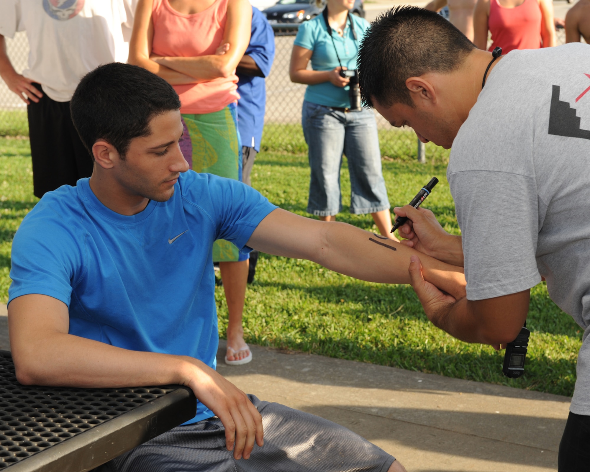 WHITEMAN AIR FORCE BASE, Mo. -  Airman 1st Class John Proen, 509th Finance Comptroller, patiently receives his number assignment from Staff Sgt.  Henry Lopez, Whiteman Fitness Center programs director, before triathlon event.  (U.S. Air Force photo/Senior Airman Cory Todd)