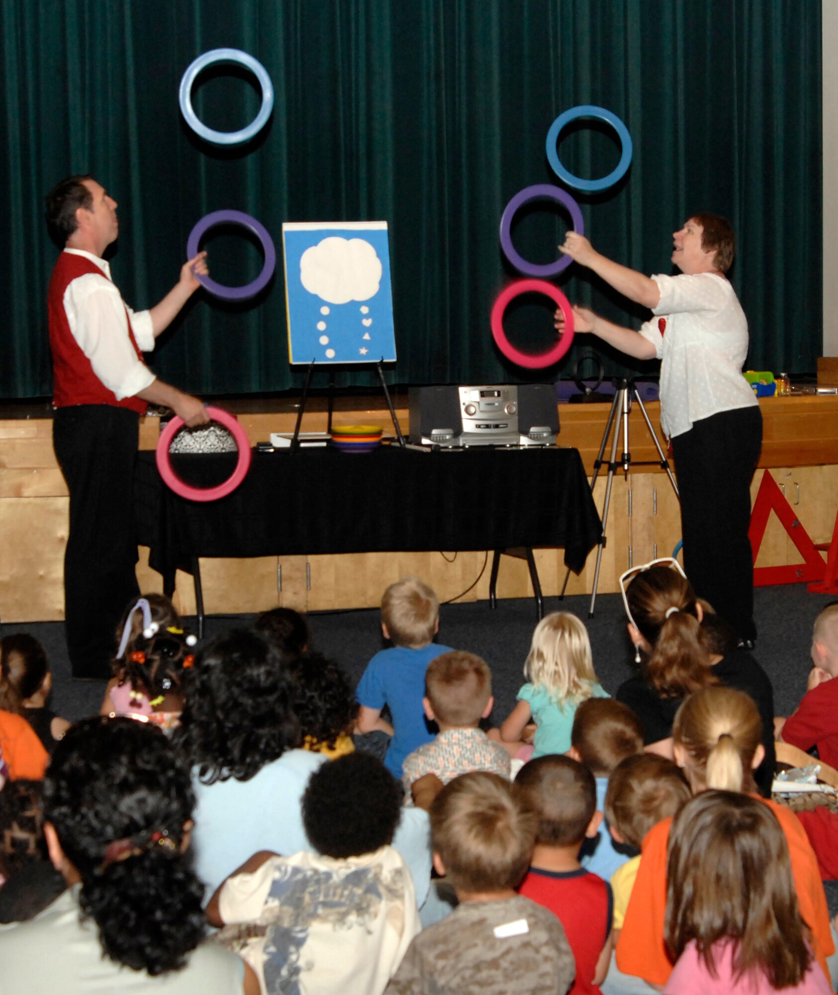 MCCONNELL AIR FORCE BASE, Kan. -- Jay and Leslie Cady, Laughing Matters “United Imaginations”, juggle rings for a group of children at the Robert J. Dole Community Center ballroom, June 26. The Cady’s have performed in more than 30 states as well as seven foreign countries and have headlined for acts such as Cirque du Soliel. (Photo by Senior Airman Laura Suttles)