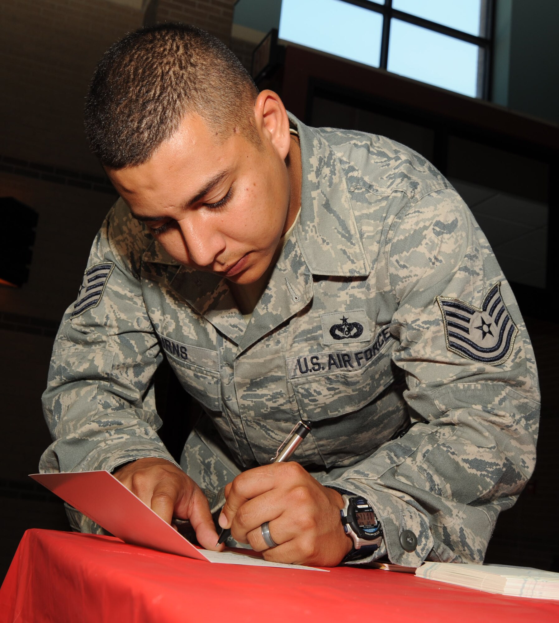 MCCONNELL AIR FORCE BASE, Kan. -- Tech Sgt Howard Burns, 931st Civil Engineer Squadron, signs a card for Maj. Don Cummings, a Tuskegee Airmen, June 24. Major Cummings was recently released from the intensive care unit in a Columbus, Ohio hospital. Airmen around McConnell Air Force Base are reaching out to the hero to offer him their get-well wishes. (Photo by Senior Airman Roy Lynch) 