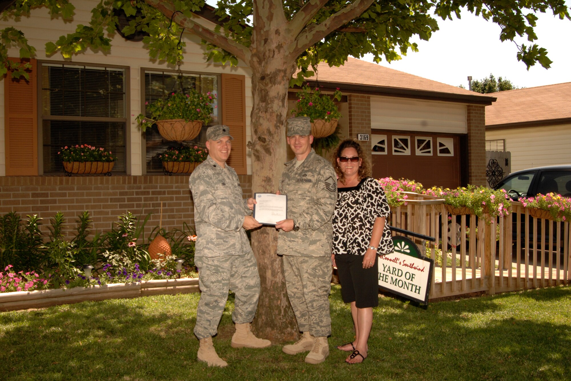 MCCONNELL AIR FORCE BASE, Kan. -- Lt. Col. Roman Hund, 22nd Mission Support Group deputy commander, recognizes Master Sgt. Christopher Culbreth, 22nd Civil Engineer Squadron, along with wife Eva for winning the yard of the month, June 29. (Photo by Senior Airman Laura Suttles)