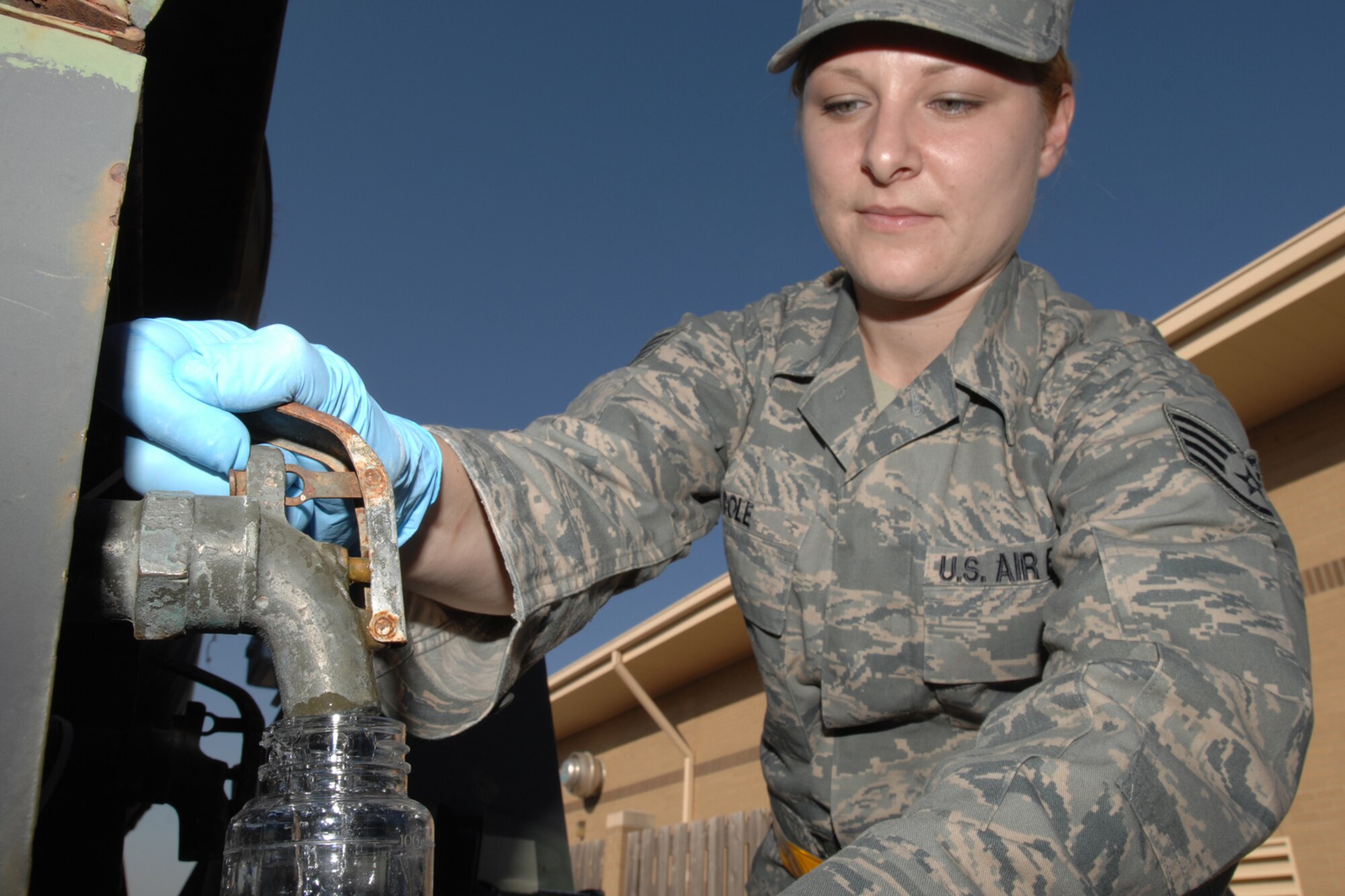 MCCONNELL AIR FORCE BASE, Kan.-- Staff Sgt. Crystal Cole takes a sample of water from a water storage tank (water buffalo), to test the pH, bacteria, and chlorine levels June 25 during a Nuclear Operational Readiness Exercise. The water is tested prior to being consumed by base personnel. (Photo by Staff Sgt. Jamie Train)