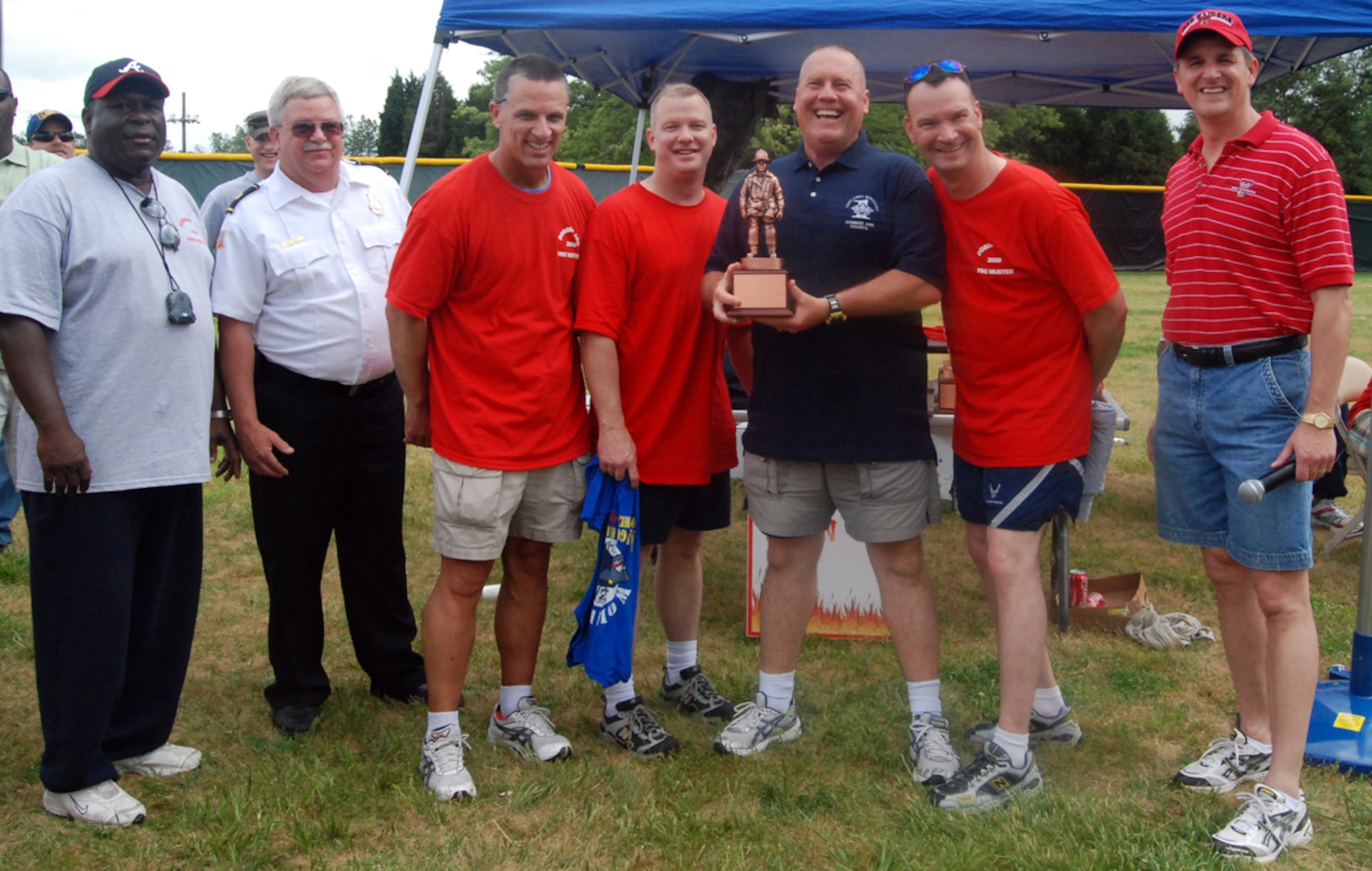 (Left to right) Dobbins Fire Chiefs William Wilson and John Hicks help present Chief Master Sgts. Kevin Davalos, 94th Services Squadron, Kent Smith, 80th Aerial Port Squadron, John Anderson, 94th Airlift Wing command chief, and David Wells, 22nd Air Force, with an award for the Fire Muster runner-up trophy with the help of Col. Heath Nuckolls, 94th AW commander, during the annual Family Day May 2.