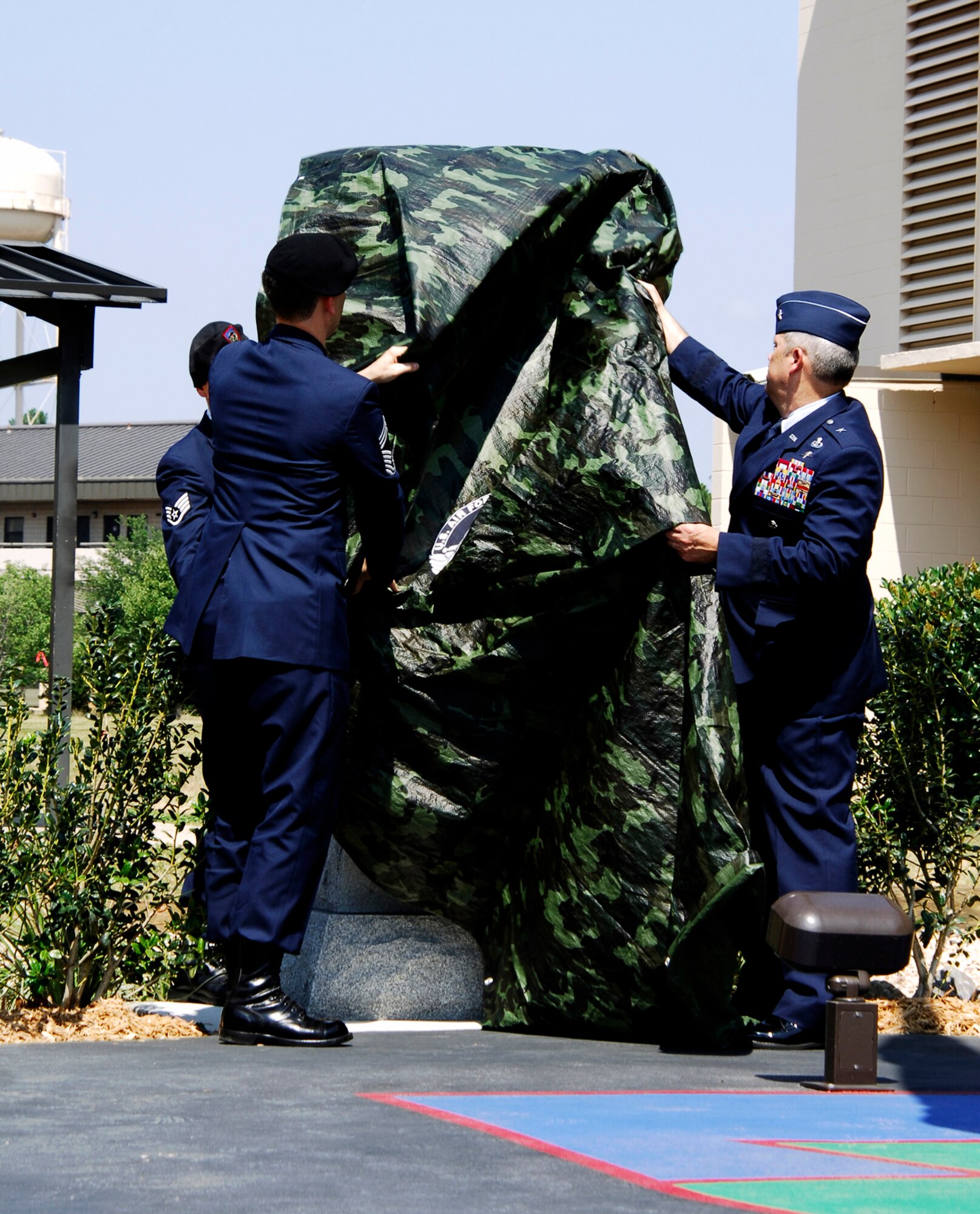 HURLBURT FIELD, Fla. --  Chief Master Sgt. David Devine, Headquarters Air Force Tactical Air Control Party career field manager and Brig. Gen. Michael Longoria, 93rd Air Ground Operations Wing commander, unveil an eight-foot monument June 26 honoring the accomplishments and sacrifices of TACP members past and present. (U.S. Air Force photo/Senior Airman Sheila DeVera)