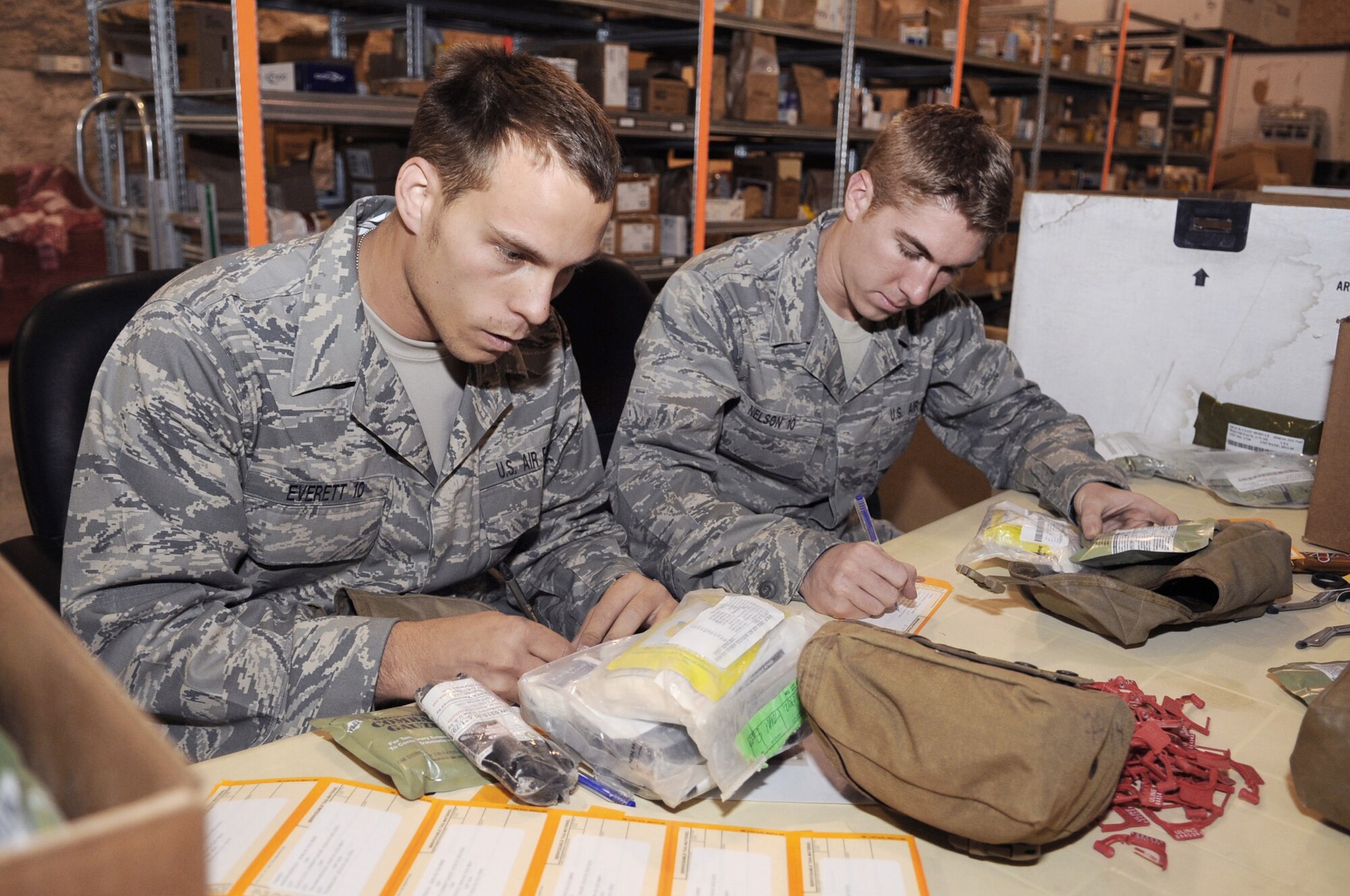 U.S. Air Force Academy Cadets Dan Everett and Erik Nelson build individual first aid kits for deploying members heading downrange while visiting the 379th Expeditionary Medical Group facilities June 25 at an air base in Southwest Asia. The cadets are part a program called Operation Air Force, which gives them exposure to the operational side of the Air Force before being commissioned. Cadet Everett hails from Isanti, Minn., and Cadet Nelson is from Montville, Conn. Both are visiting from the Academy. to gain knowledge about operations Iraqi Freedom and Enduring Freedom. (U.S. Air Force photo/Staff Sgt. Joshua Garcia) 