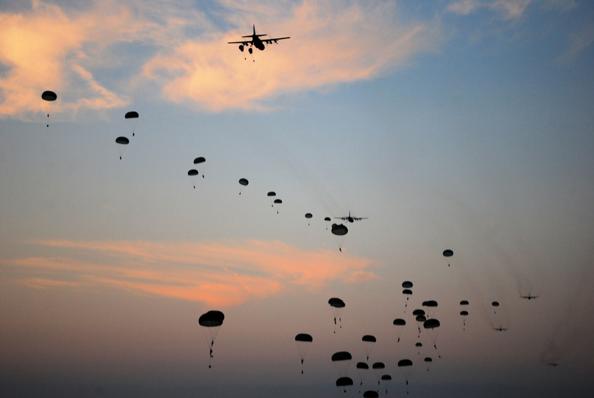 Paratroopers from the 82nd Airborne Division float from the sky during a noncombatant evacuation operation held at Mackall Army Airfield, June 22-26. During the exercise, Airmen from the 621st Contingency Response WIng evacuated more than 1,000 Soldiers and role players when the environment in the fictional country of Chatu became hostile. (U.S. Air Force photo/Staff Sgt. Nicholas Phelps)