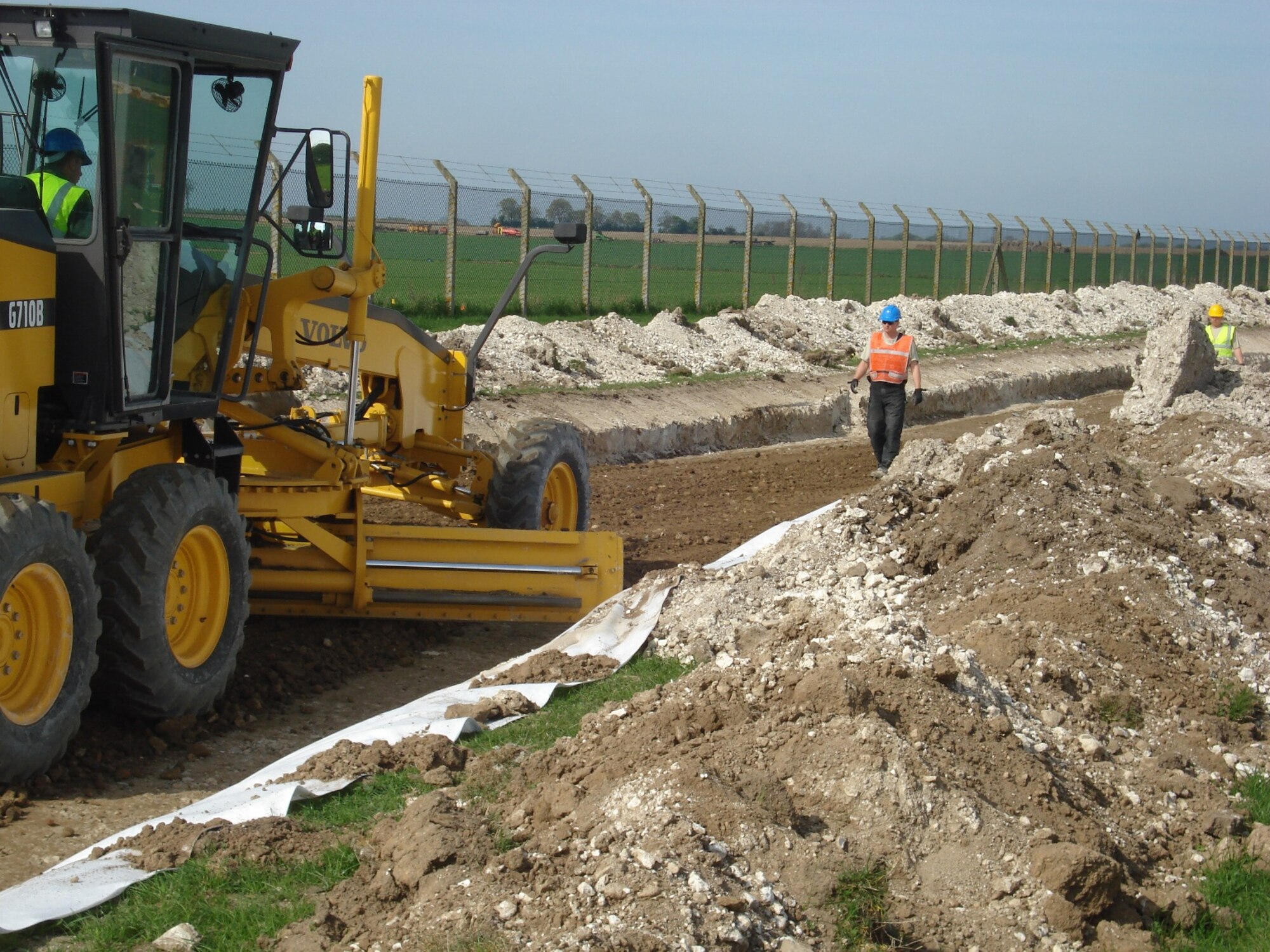 RAF FELTWELL, England--SSgt Ian Aeppli, Utilities Systems Craftsman, 86th Construction and Training Squadron Military Construction Flight, SrA Jacob Bailey, Pavements & Equipment Operator, 86th CTS/MCF, and SSgt Bobby Martin, Pavements & Equipment Operator, 86th CTS/MCF, SSgt Aeppli gains real world grading experience during recent construction at RAF Feltwell. (USAF photo)

