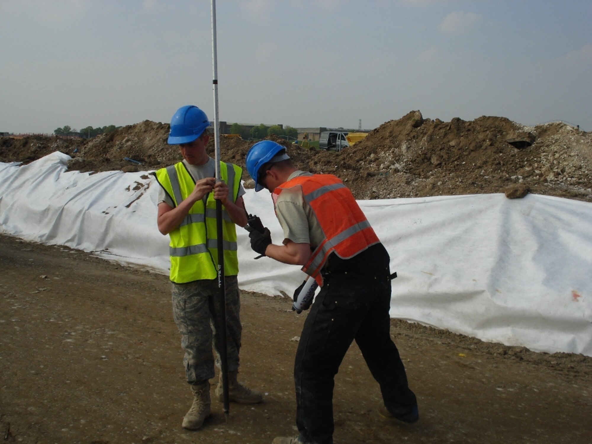 RAF FELTWELL, England--SSgt Ian Aeppli, Utilities Systems Craftsman, 86th Construction and Training Squadron Military Construction Flight, and SrA Jacob Bailey, Pavements & Equipment Operator, 86th CTS/MCF, conduct elevation checks  during grading operations for a new perimeter road at RAF Feltwell. (USAF photo)

