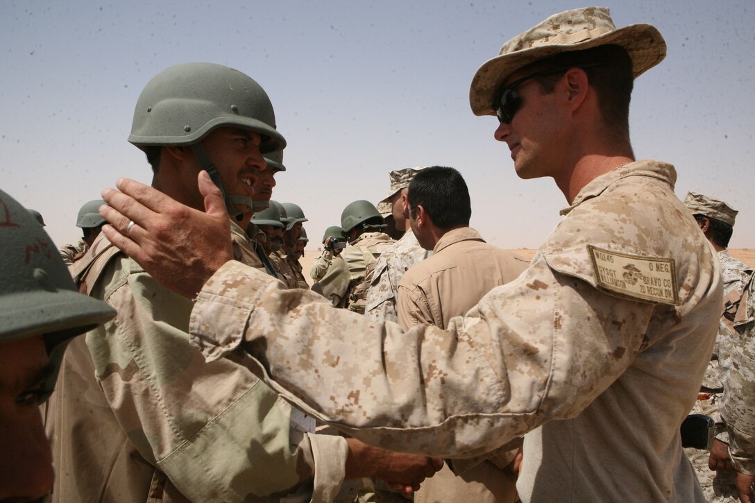 Gunnery Sgt. Christopher Williamson, the platoon sergeant of Reconnaissance Platoon, Regimental Combat Team 8, congratulates an Iraqi commando during the commandos’ graduation ceremony from their monthlong training exercise, July 2, 2009.  Williamson said the commandos can take the training they received and build on it to become a stronger, more capable force.
