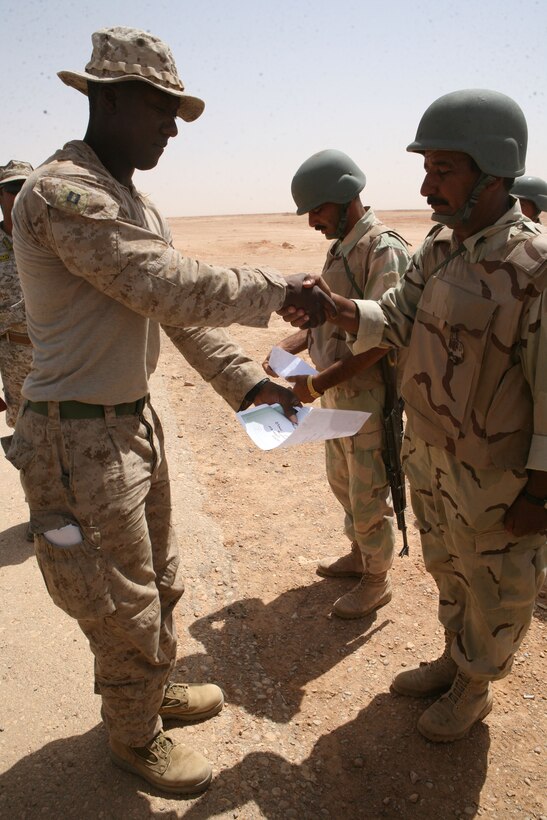 Capt. Joe Clarke, the platoon commander of Reconnaissance Platoon, Regimental Combat Team 8, gives an Iraqi commando his certificate during the commandos’ graduation ceremony from their monthlong training exercise, July 2, 2009.  Clarke credits the Marines in his platoon with the success of the training.