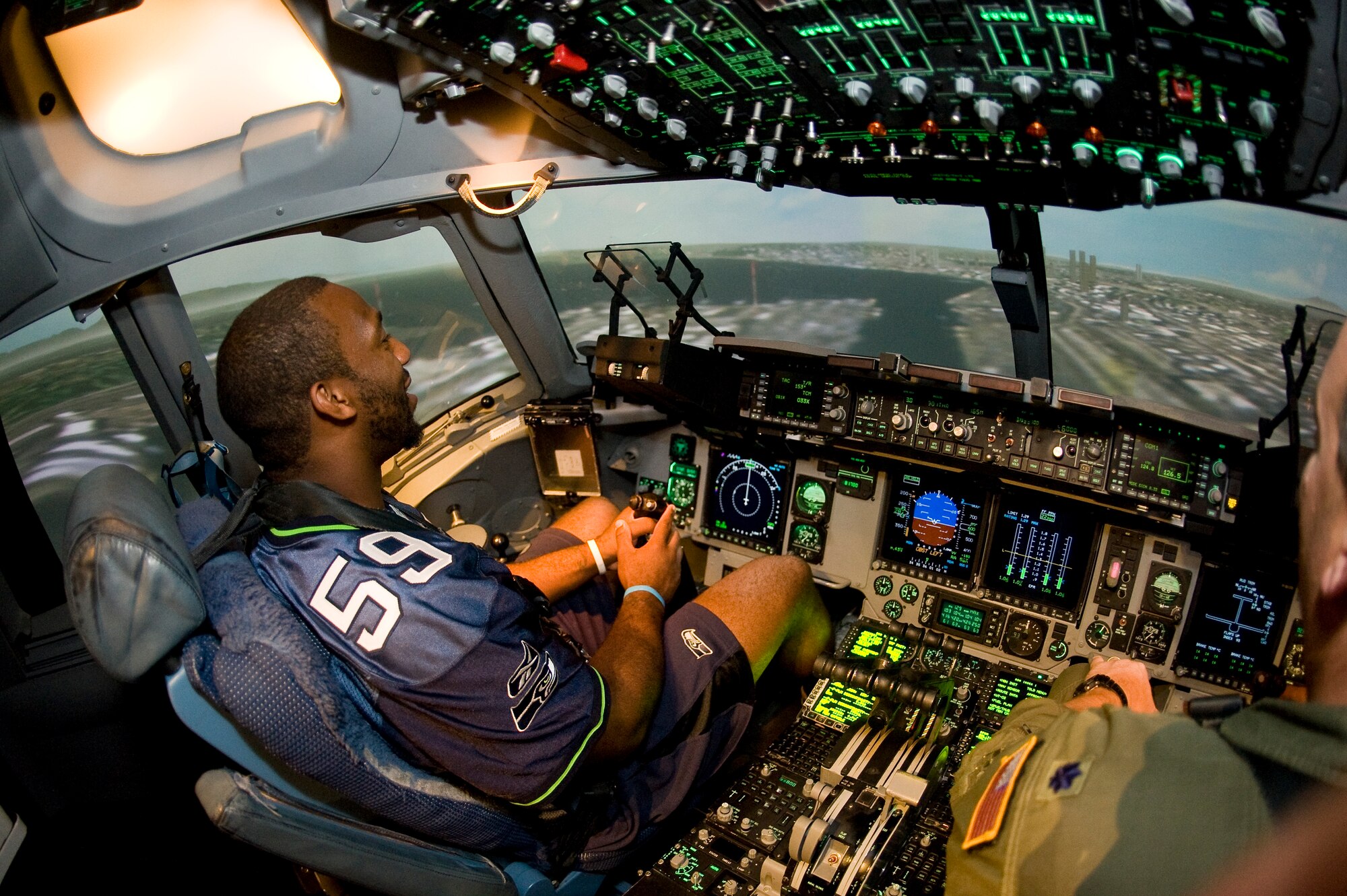 Seattle Seahawks rookie linebacker Aaron Curry mans the controls in one of McChord’s C-17 Globemaster III simulators June 26 as part of a visit to the base. In addition to experiencing the simulator, Mr. Curry signed autographs at the base exchange. (U.S. Air Force photo/Abner Guzman)