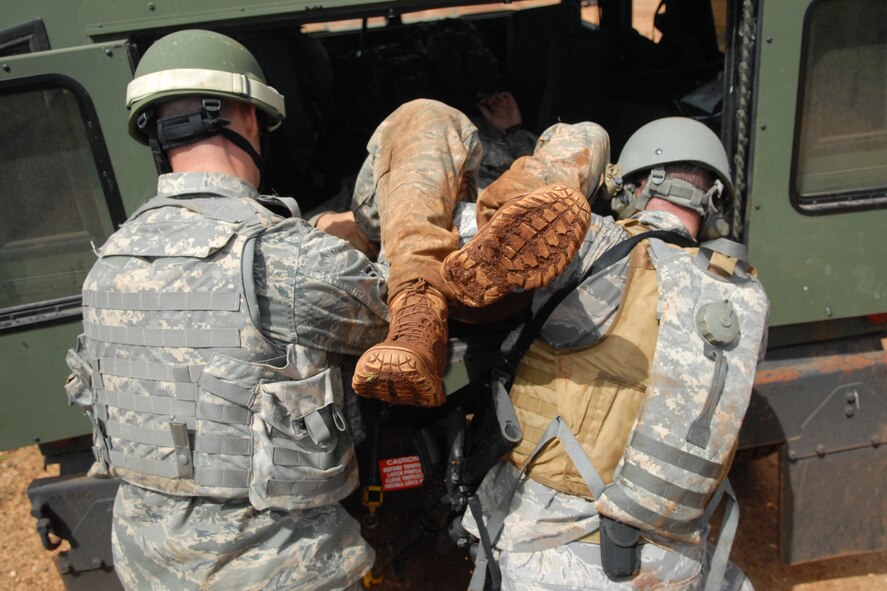 WHEELER ARMY AIR FIELD, Hawaii -- 25th Air Support Operations Squadron Tactical Air Control Party Airmen move a casualty to a safer area after their patrol convoy was attacked by opposing forces during a field training exercise June 24 on Wheeler Army Air Field?s East Range. Their training was enhanced by Airmen from 15th Civil Engineer Squadron Explosive Ordnance Disposal flight, and Soldiers from the 25th Infantry, Alpha Company, 114th Infantry Battalion, at Scofield Barracks, Hawaii, playing the part of opposing forces, or OPFOR. (U.S. Air Force photo/Staff Sgt. Mike Meares)