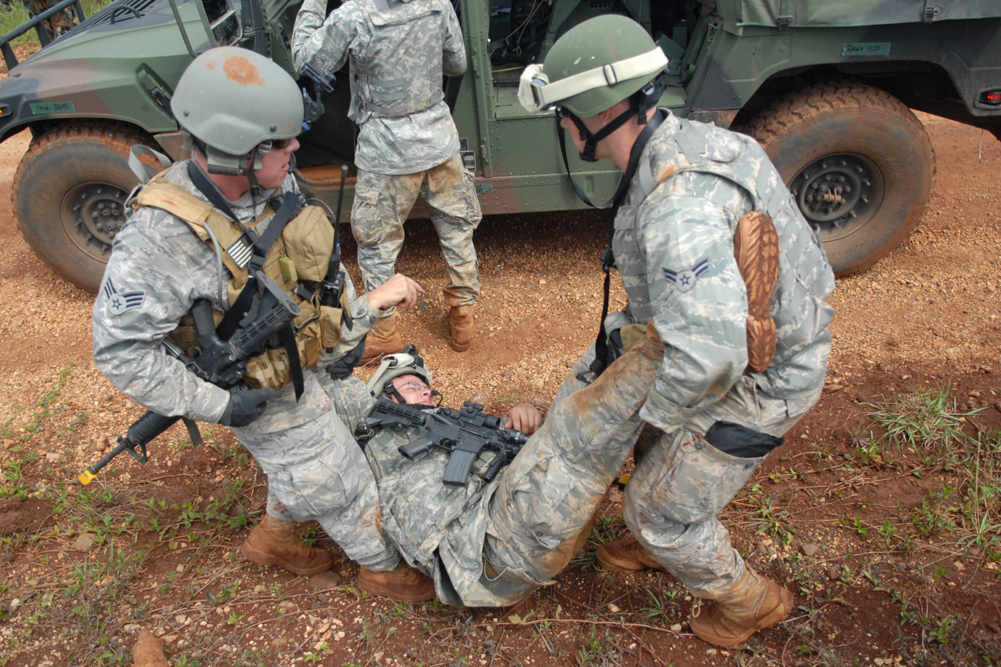 WHEELER ARMY AIR FIELD, Hawaii -- 25th Air Support Operations Squadron Tactical Air Control Party Airmen move a casualty to a safer area after their patrol convoy was attacked by opposing forces during a field training exercise June 24 on Wheeler Army Air Field?s East Range. Their training was enhanced by Airmen from 15th Civil Engineer Squadron Explosive Ordnance Disposal flight, and Soldiers from the 25th Infantry, Alpha Company, 114th Infantry Battalion, at Scofield Barracks, Hawaii, playing the part of opposing forces, or OPFOR. (U.S. Air Force photo/Staff Sgt. Mike Meares)