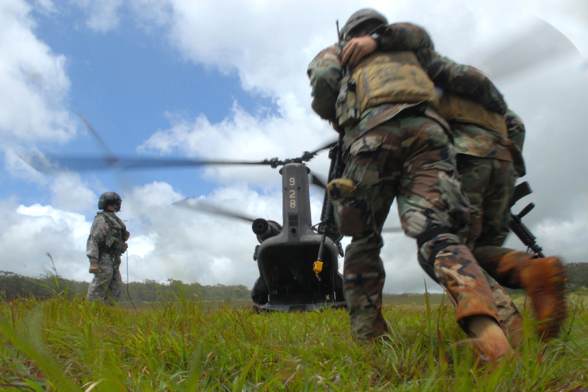 WHEELER ARMY AIR FIELD, Hawaii -- Staff Sgt. Anthony Stewart, 25th Air Support Operations Squadron electrical engineer, is helped to a CH-47 Chinook for aeromedical medical evacuation by Airman 1st Class Daniel Meyer, a 25th ASOS Tactical Air Control Party, during  field training exercises June 24. Airmen from the 25th ASOS, including Radio Operators, Maintainers and Drivers, camped out for four days to sharpen proficiencies necessary for upgrade training to become combat mission-ready Joint Terminal Attack Controllers. Opposing forces, played by Airmen from 15th Civil Engineer Squadron Explosive Ordnance Disposal flight and Soldiers from the 25th Infantry, Alpha Company, 114th Infantry Battalion, at Scofield Barracks, Hawaii, provided the sights and sounds of combat action during ambushes throughout the training. (U.S. Air Force photo/Staff Sgt. Mike Meares)