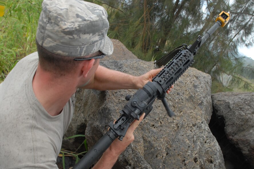 WHEELER ARMY AIR FIELD, Hawaii -- Staff Sgt. Ryan Bobzin, 15th Civil Engineer Squadron Explosive Ordnance Disposal flight, prepares to attack an approaching convoy from an elevated position during a field training exercise at the Army Wheeler Airfield East Range June 24. As a member of the opposing forces, or OPFOR, he was responsible for making the sights and sounds of battle as realistic as possible. Sergeant Bobzin hails from Rochester, N.Y. (U.S. Air Force photo/Mike Meares)