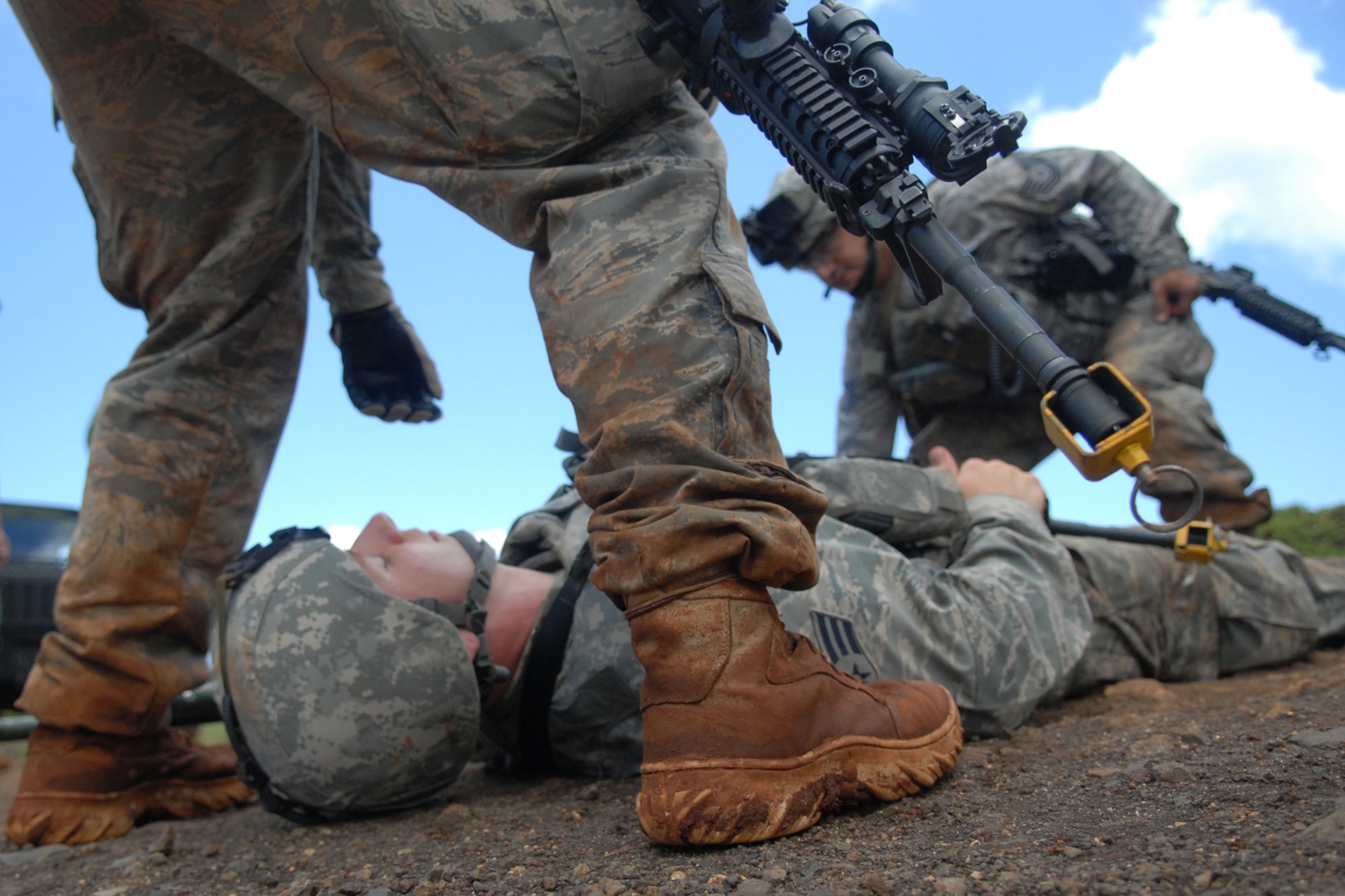 WHEELER ARMY AIR FIELD, Hawaii -- Tech. Sgt. Alejandro Castillo and Airman 1st Class Chris Tamblyn, 25th Air Support Operations Squadron Tactical Air Control Party, to prepare to roll a casualty onto a stretcher to be transported on a CH-47 Chinook for aeromedical evacuation during field training June 24. Radio Operators, Maintainers and Drivers camped out for four days to sharpen proficiencies necessary for upgrade training to become combat mission-ready Joint Terminal Attack Controllers. Opposing forces, played by Airmen from 15th Civil Engineer Squadron Explosive Ordnance Disposal flight, and Soldiers from the 25th Infantry, Alpha Company, 114th Infantry Battalion, at Scofield Barracks, Hawaii, provided the sights and sounds of combat action during ambushes throughout the training. (U.S. Air Force photo/Staff Sgt. Mike Meares)