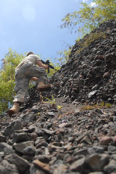 WHEELER ARMY AIR FIELD, Hawaii -- Senior Airman Robert Wester, 15th Civil Engineer Squadron Explosive Ordnance Disposal flight, prepares to attack an approaching convoy from an elevated position during a field training exercise at the Army Wheeler Airfield East Range June 24. As a member of the opposing forces, or OPFOR, he was responsible for making the sights and sounds of battle as realistic as possible. Airman Wester is from Knoxville, Tenn. (U.S. Air Force photo/Mike Meares)