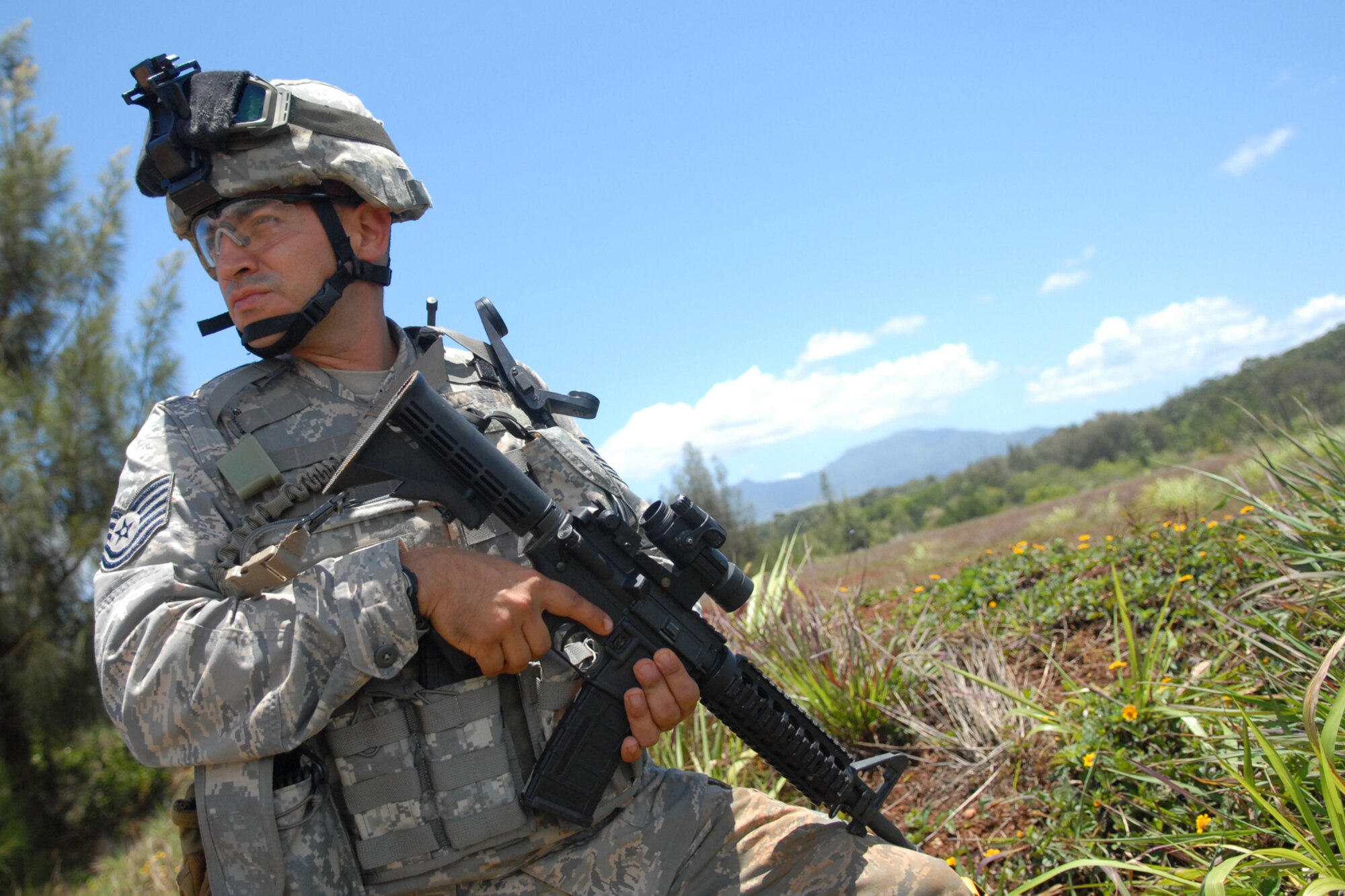 WHEELER ARMY AIR FIELD, Hawaii -- Tech. Sgt. Alejandro Castillo, 25th Air Support Operations Squadron Tactical Air Control Party, provides overwatch for a patrol checking on the validity of a possible improvised explosive device during a field training exercise June 24 on Wheeler Army Air Field's East Range. Radio Operators, Maintainers and Drivers camped out for four days to sharpen proficiencies necessary for upgrade training to become combat mission-ready Joint Terminal Attack Controllers. Opposing forces, played by Airmen from 15th Civil Engineer Squadron Explosive Ordnance Disposal flight, and Soldiers from the 25th Infantry, Alpha Company, 114th Infantry Battalion, at Scofield Barracks, Hawaii, provided the sights and sounds of combat action during ambushes throughout the training. (U.S. Air Force photo/Staff Sgt. Mike Meares)