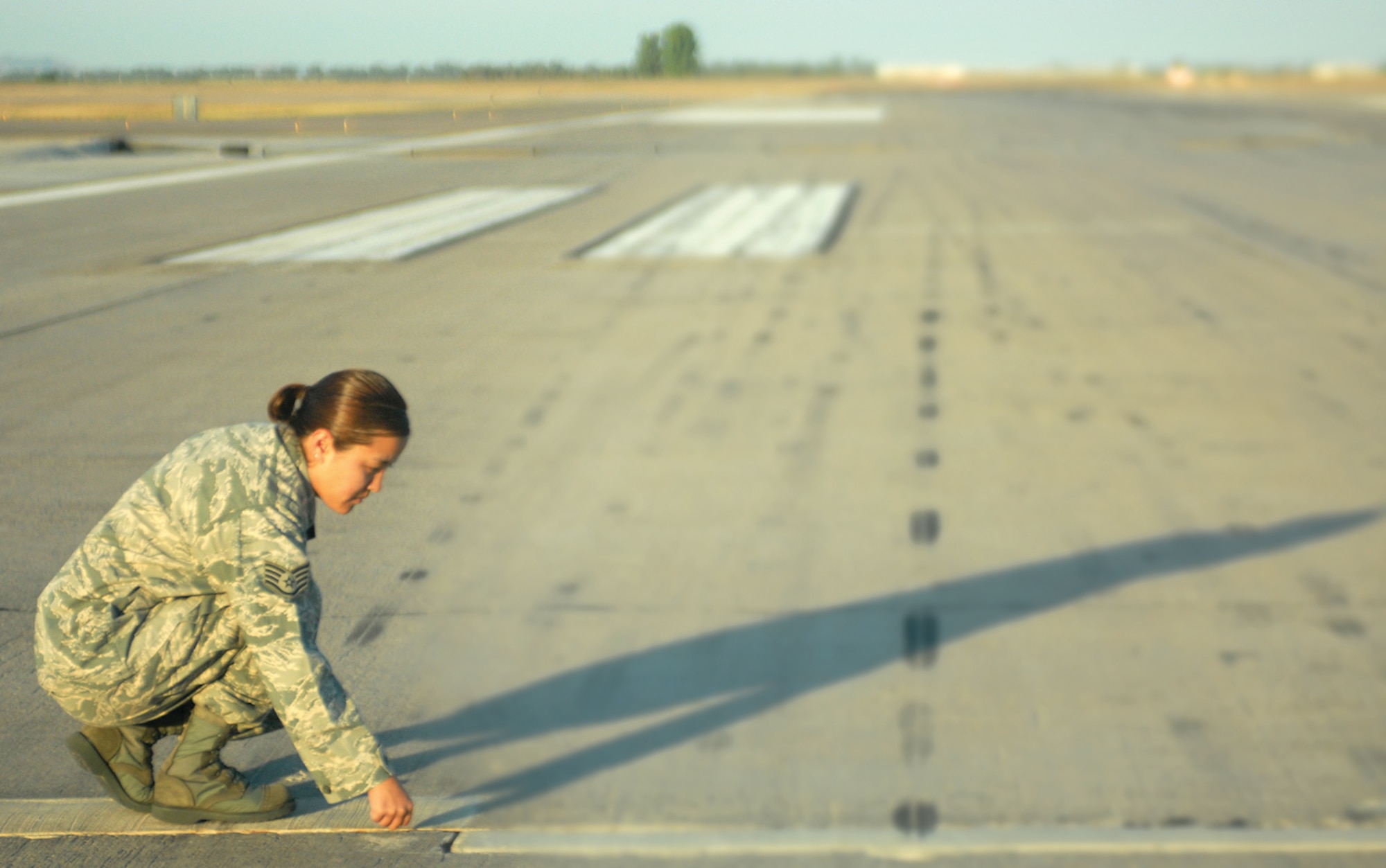 Staff Sgt. Sara Piper, 56th Operations Support Squadron Air Field Management Operations, checks for foreign object debris on the Luke Air Force Base flightline to prevent damage to aircraft. The unit conducts FOD checks every morning around 5:45 a.m. (U.S. Air Force photo/ Airman 1st Class Sandra Welch)
