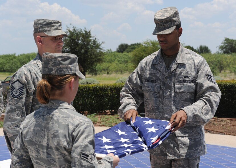 DYESS AIR FORCE BASE, Texas – Dyess Honor Guard members Staff Sgt. Raul Gonzalez (back) and Airman First Class Tera Defrias (front) fold the flag as Master Sgt. Robert Fournier (center) looks on during a retreat ceremony July 2 at the Dyess parade grounds here. A retreat ceremony signifies the end of a duty day; and in this special circumstance pays tribute to the July Fourth holiday and celebrates our countries’ independence. (U.S. Air Force photo by Senior Airman Jennifer Romig)