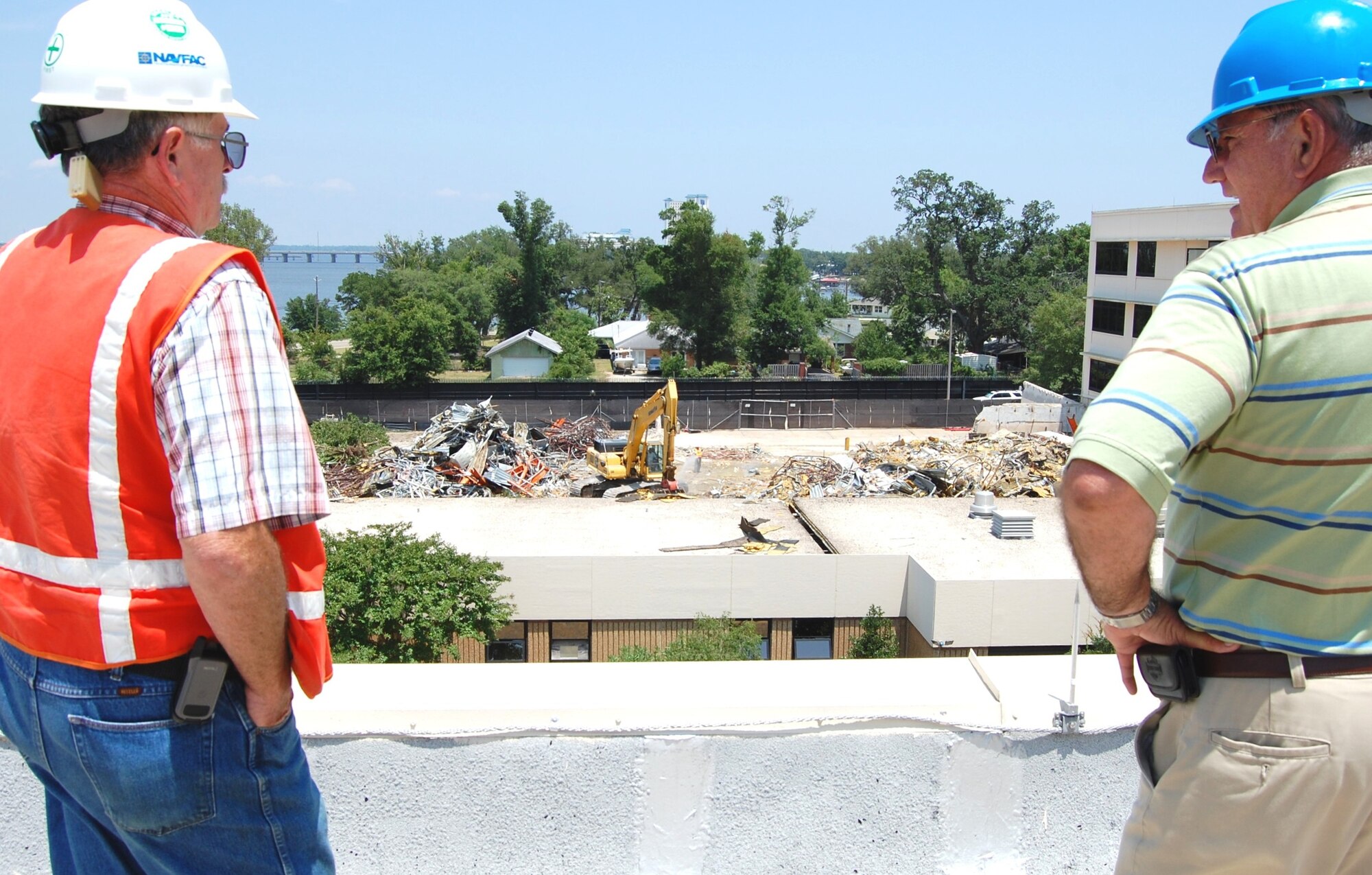 Kevin Sullivan, left, U.S. Navy resident officer in charge of construction, and Michael Chatham, 81st Medical Support Squadron facilities management, watch contractors with Carothers Construction demolish a portion of Keesler Medical Center’s “D” wing June 15.  Demolition, scheduled to be finished by Sept. 1, makes way for the new $68 million inpatient tower.  Construction begins in late September or early October and should be completed in October 2011.  (U.S. Air Force photo by Steve Pivnick)