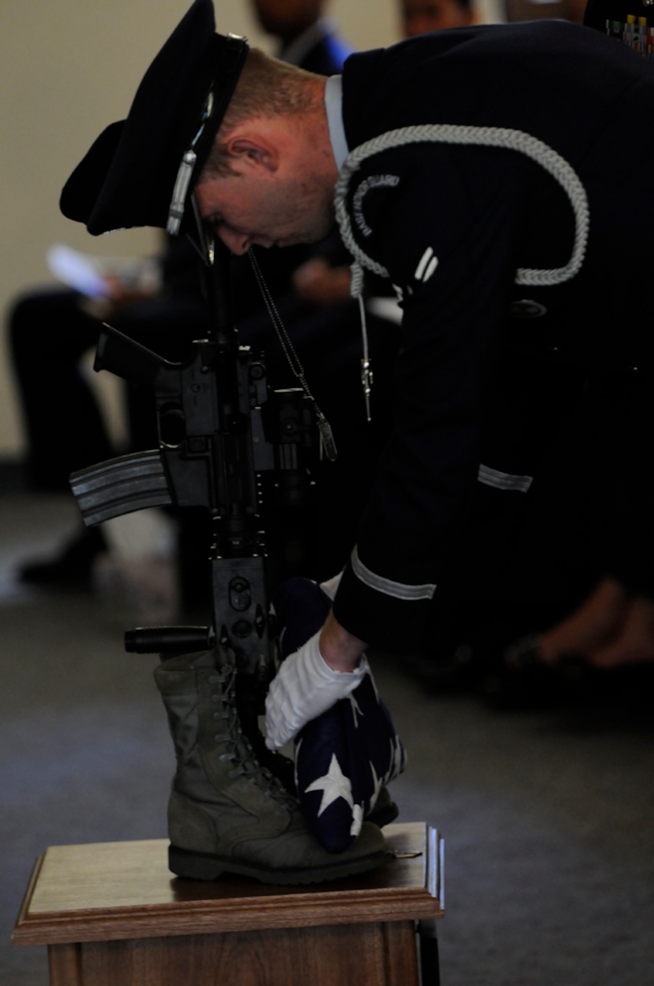 Airman 1st Class Jeremy Davidson, 65th Medical Operations Squadron, and base honor guard member, places a folded American flag on the memorial display during the memorial service for Senior Airman Amber Finnell, 65th Security Forces Squadron, at Lajes Field July 2. Airman Finnell was from East Tawas, Mich. and entered the Air Force in Feb. 2004.  She had been previously stationed at Minot AFB, N.D. and Sather AB, Baghdad, Iraq; she passed away on June 30, 2009.  (U.S. Air Force photo by Tech. Sgt. Darrell I. Dean)