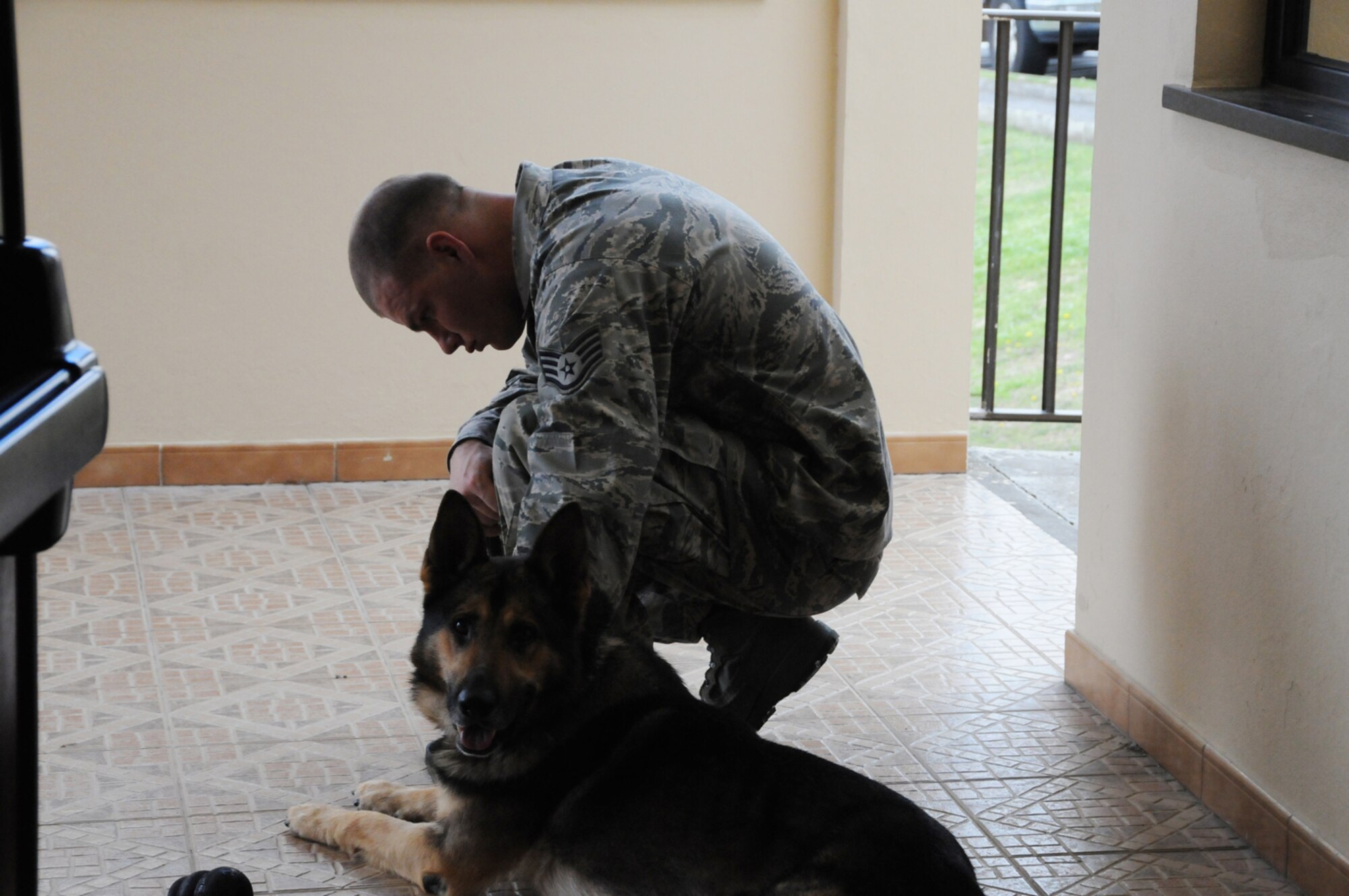 Staff Sgt. Joshua Rose and his dog, Dan, 65th Security Forces Squadron, take a moment during the memorial service in honor of Senior Airman Amber Finnel, 65th SFS, at Lajes Field July 2. Airman Finnell was from East Tawas, Mich. and entered the Air Force in Feb. 2004.  She had been previously stationed at Minot AFB, N.D. and Sather AB, Baghdad, Iraq; she passed away on June 30, 2009.  (U.S. Air Force photo by Tech Sgt. Rebecca F. Corey)