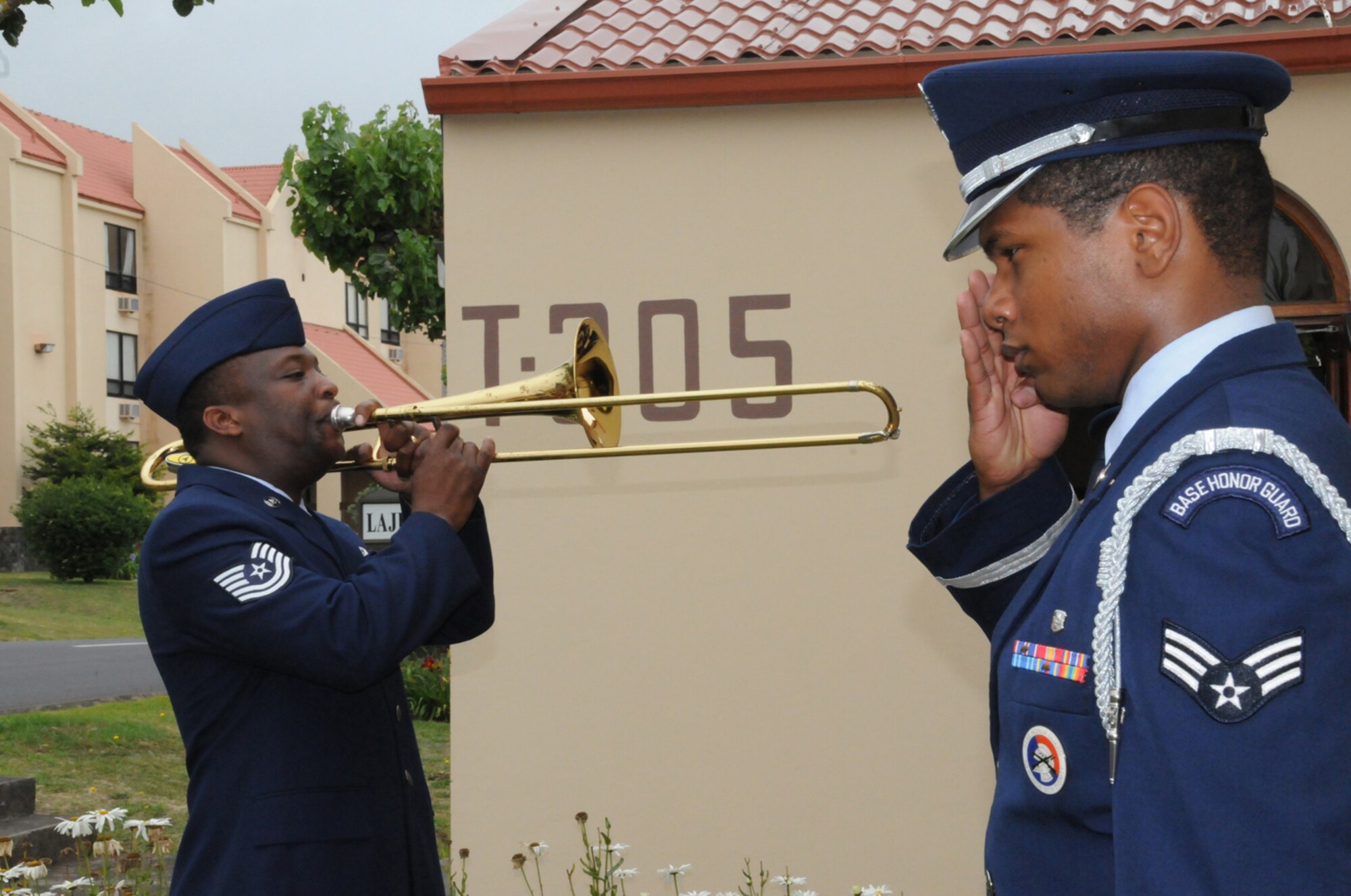 Tech. Sgt. Richard Williams, 65th Civil Engineer Squadron, plays Taps as Senior Airman John Parker, 65th Medical Operations Squadron, salutes during the memorial service in honor of Senior Airman Amber Finnel, 65th Security Forces Squadron, at Lajes Field July 2. Airman Finnell was from East Tawas, Mich. and entered the Air Force in Feb. 2004.  She had been previously stationed at Minot AFB, N.D. and Sather AB, Baghdad, Iraq; she passed away on June 30, 2009.  (U.S. Air Force photo by Tech Sgt. Rebecca F. Corey)