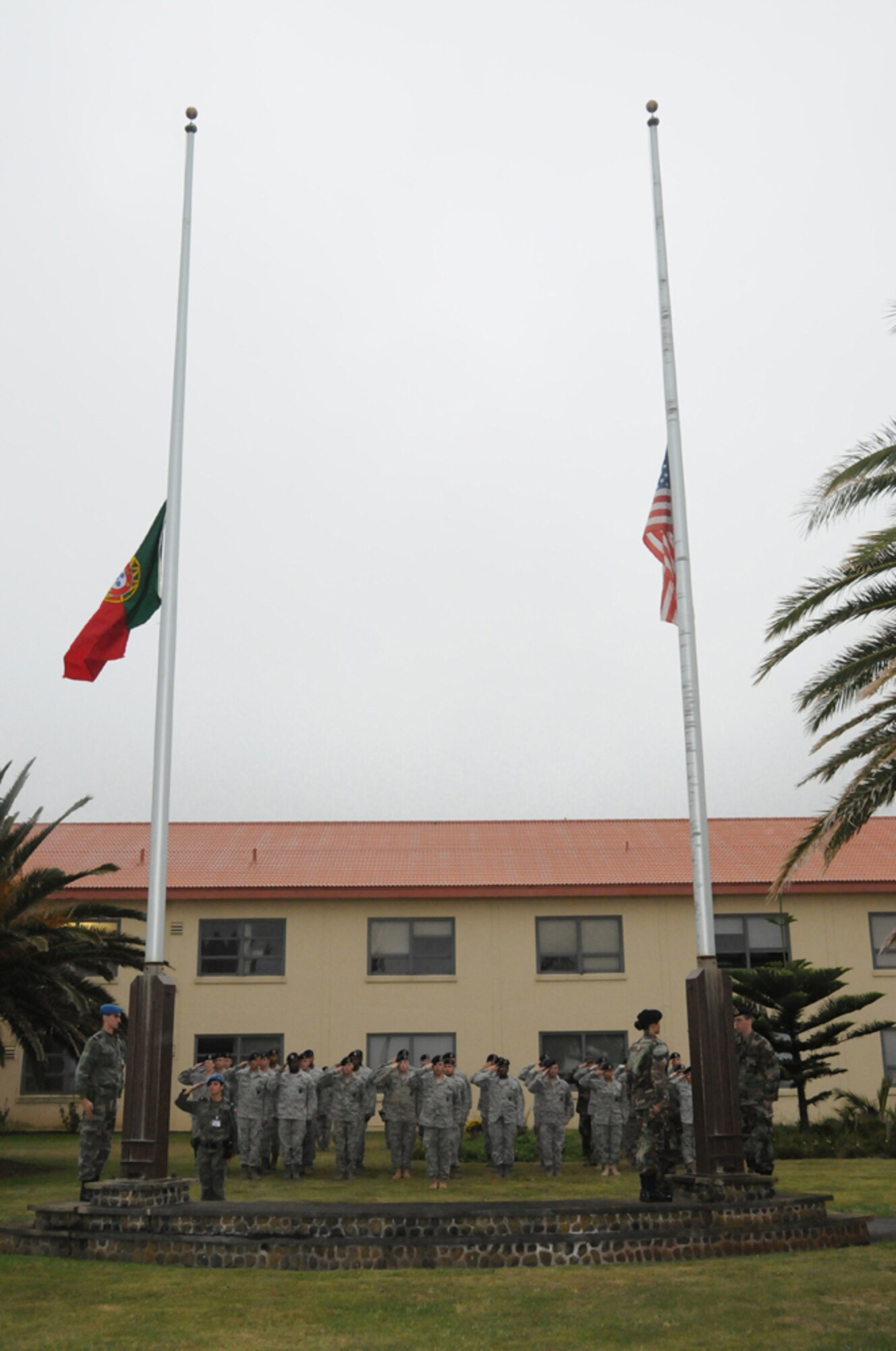 Members of the 65th Security Forces Squadron, at Lajes Field, salute as the American and Portuguese flags are flown half staff in honor of Senior Airman Amber Finell, 65th Security Forces Squadron, at Lajes Field, July 2.  Airman Finnell is from East Tawas, Mich. and entered the Air Force in Feb. 2004.  She had been previously stationed at Minot AFB, N.D. and Sather AB, Baghdad, Iraq; she passed away on June 30, 2009.  (U.S. Air Force photo by Tech Sgt. Rebecca F. Corey)