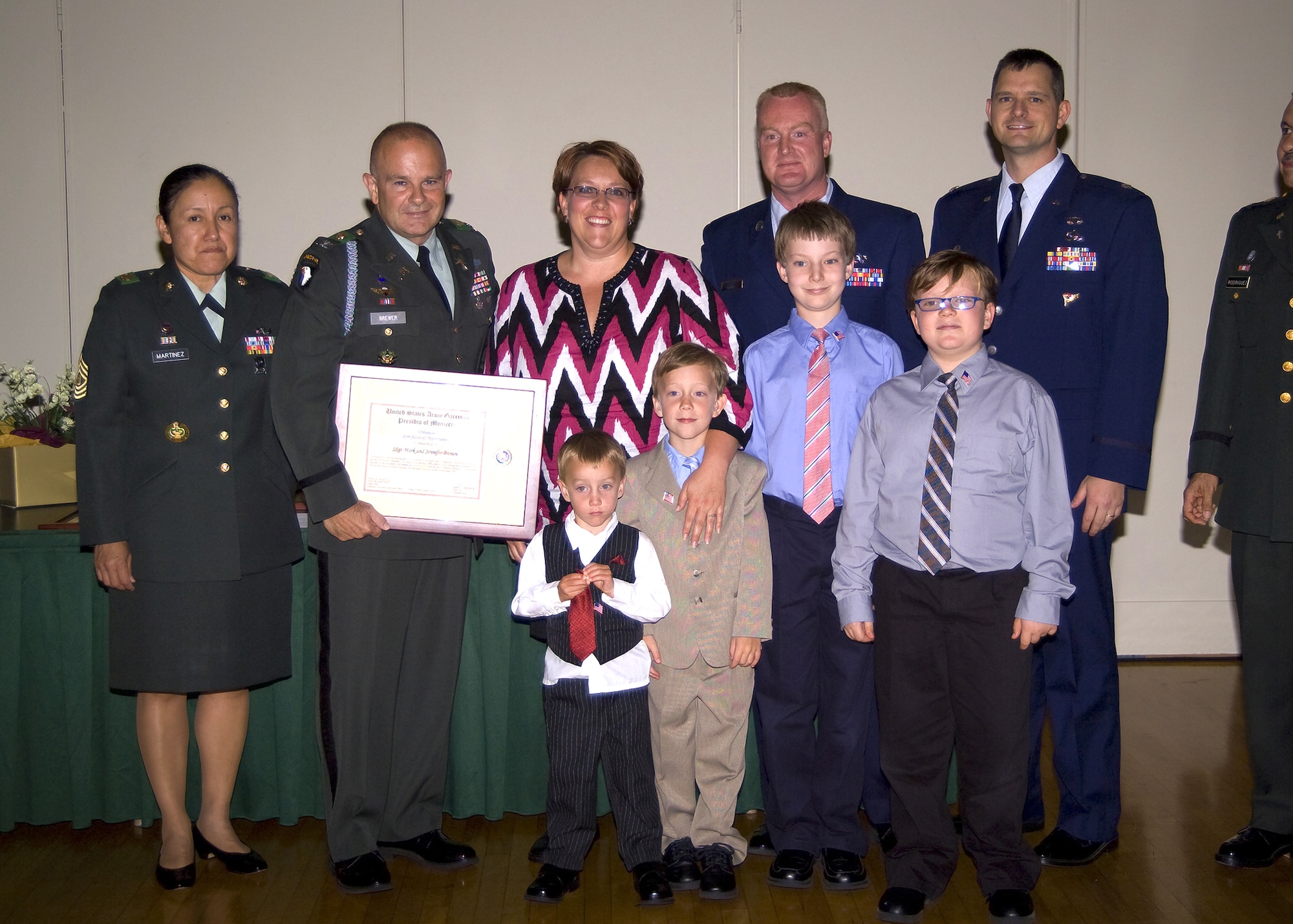 Pictured from left to right; Presidio of Monterey Garrison Command Sgt. Maj. Olga Martinez and Commander Col. Darcy Brewer, Mrs. Jennifer Brown, Staff Sgt. Mark Brown, 314th Training Squadron Commander Lt. Col. Jon Rice; front row – Staff Sgt Brown’s four sons, Dean, Beck, Stanton, and Malone Brown. (U.S.  Photo by Master Sgt. Thomas Niemczycki )