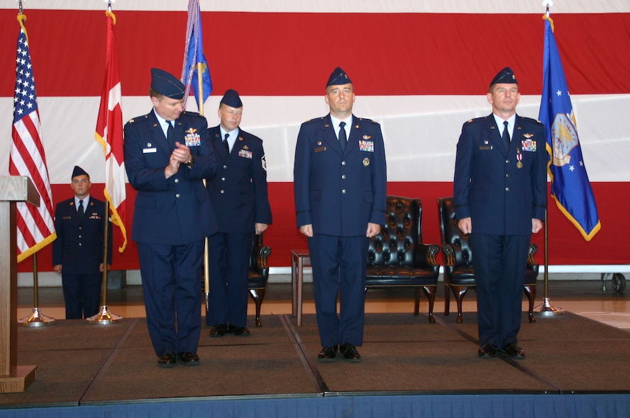 Lt. Col. Alain Poisson receives applause from his new commander, Col. George Carpenter, commander, 552nd Operations Group, after taking command of the 552nd Operations Support Squadron. Photo courtesy of 1st Lt. Kinder Blacke.