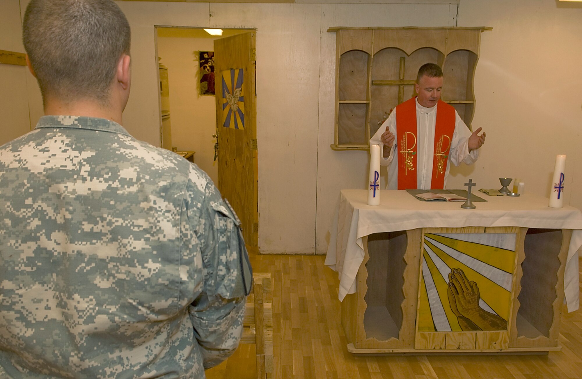 FORWARD OPERATING BASE MCHENRY, Iraq – Chaplain (Lt. Col.) Mark Rowan, 506th Air Expeditionary Group group chaplain, performs the Catholic Eucharist while celebrating Mass with Soldiers here May 31. The Long Island, N.Y., native deployed from the 374th Air Wing Chapel, Yokota Air Base, Japan, and a chaplain’s assistant from Kirkuk Regional Air Base, Iraq, fly aboard military helicopters to isolated bases to provide religious services to Soldiers. (U.S. Air Force photo / Senior Airman Jessica Lockoski)
