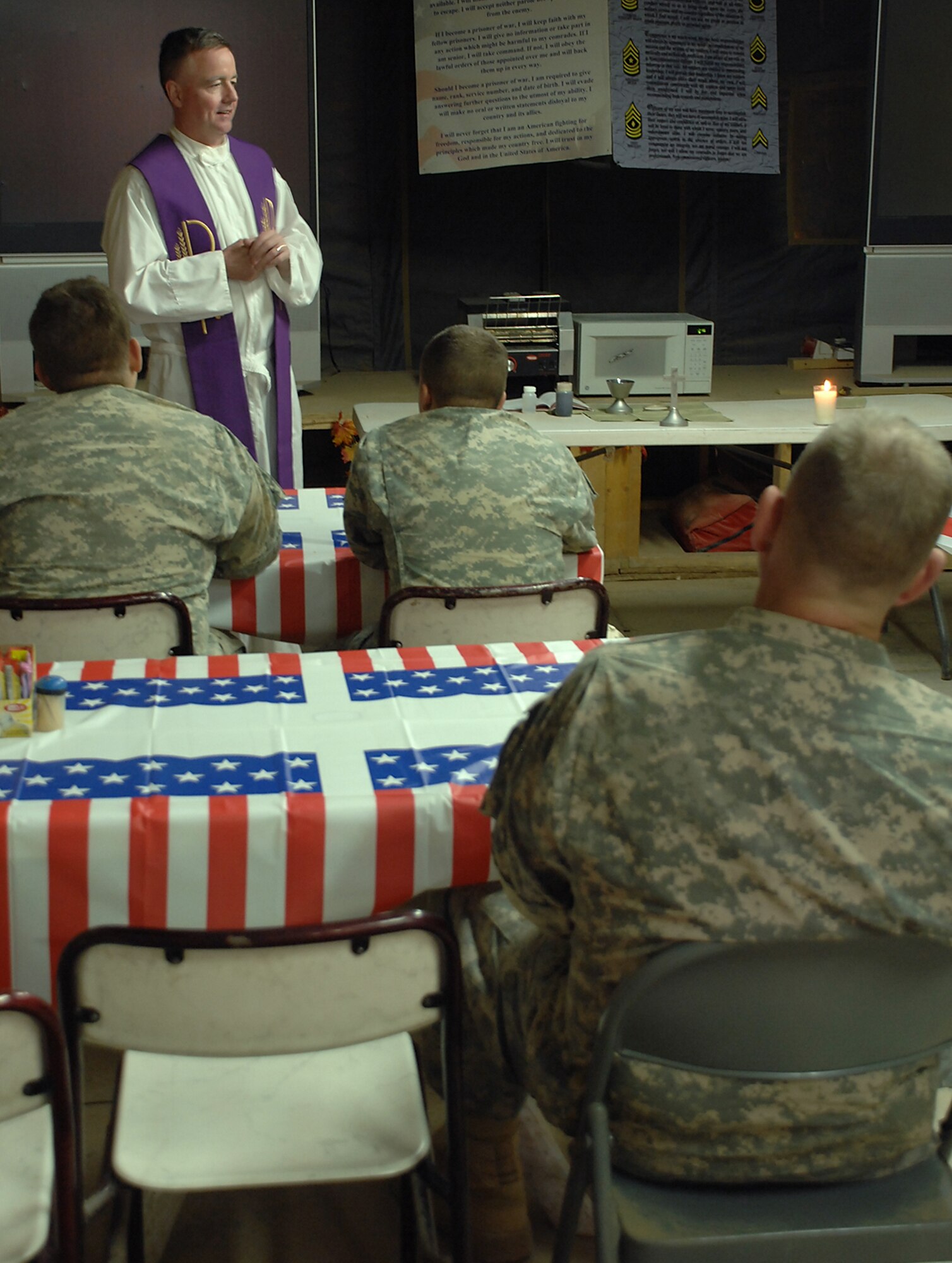 PATROL BASE DORIA, Iraq – Chaplain (Lt. Col.) Mark Rowan, 506th Air Expeditionary Group group chaplain, performs Catholic Mass for Soldiers here in a dining facility tent in March. The Long Island, N.Y., native deployed from the 374th Air Wing Chapel, Yokota Air Base, Japan, supports the 2nd Brigade Combat Team of the 1st Calvary Division’s chaplain staff by providing religious services for their Soldiers at bases outside Kirkuk Regional Air Base, Iraq. (U.S. Air Force photo / Senior Airman Jessica Lockoski)